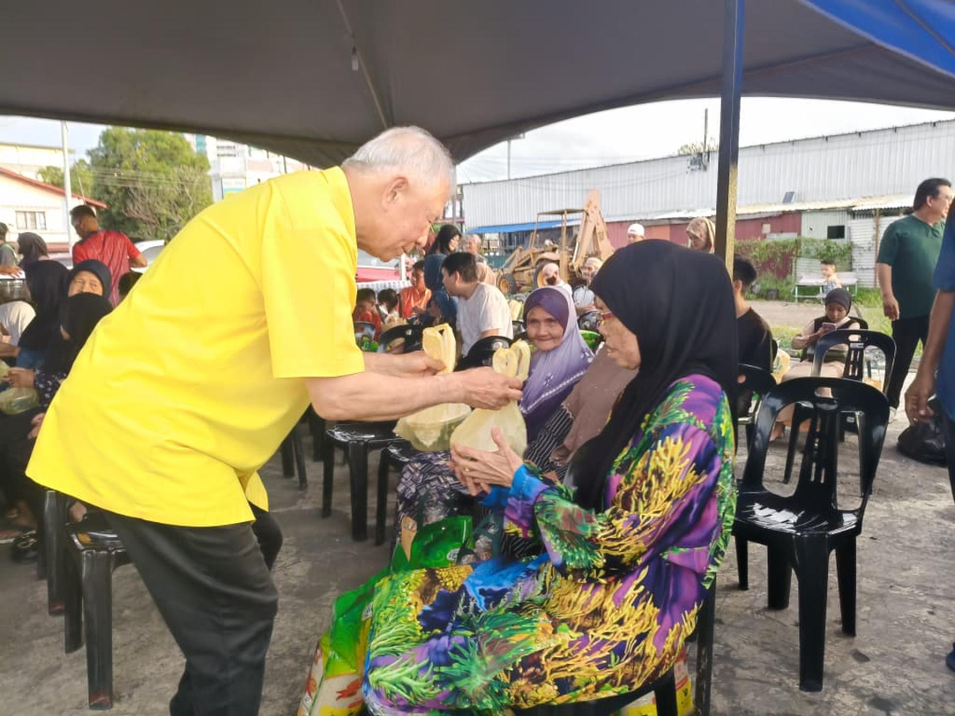 砂旅游部副部长拿督陈超耀（左）移交青包及物资予其中一名受惠者，左三为美里副市长兼砂土保党卑尔骚支部主席阿里芬。