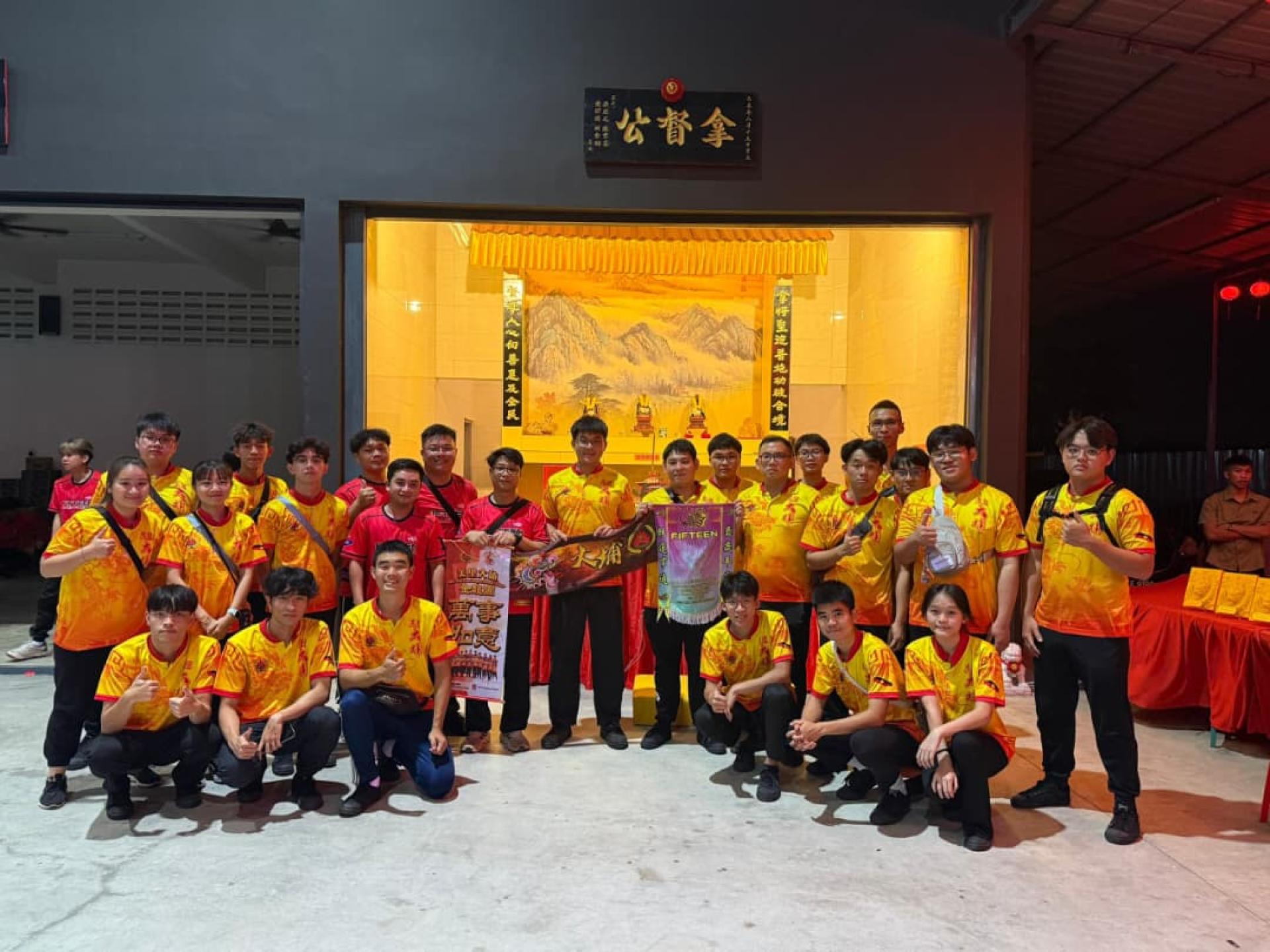 美里大埔金龙队与马来西亚柔佛州新山十五楼拿督公舞龙体育会交流后合影，站者中为美里大埔同乡会青年团团长谢家洪。