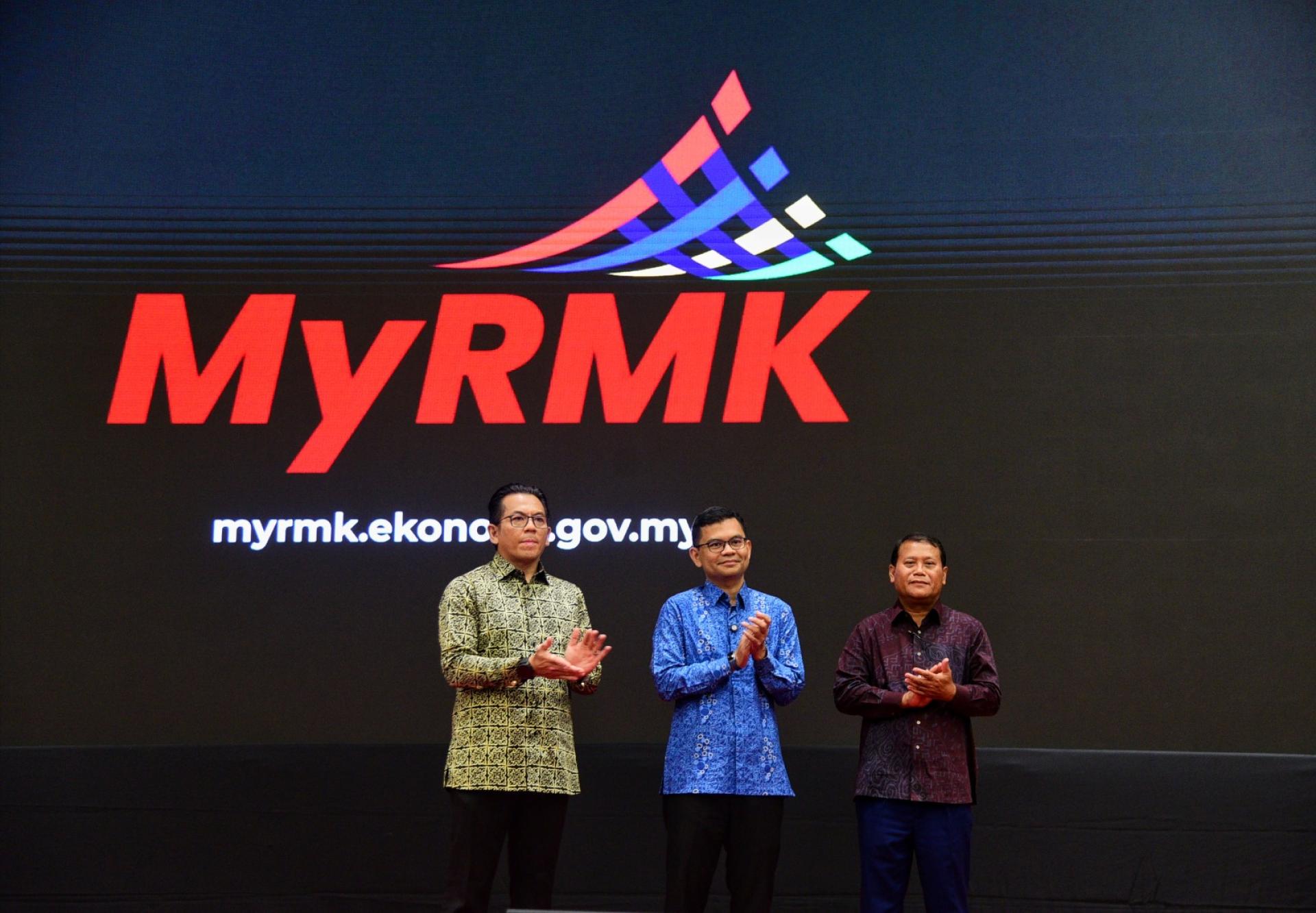 阿克马（中）在莫哈末沙哈（左起）及阿兹米陪同下，推介《第13大马计划》政策实施计划监督系统MyRMK。