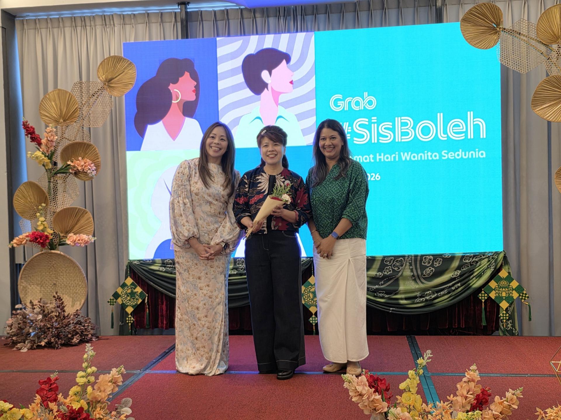 大马GRAB 董事经理傅燕玲（左）赠送花束给民主行动党朋岭区州议员杨薇讳（中）。