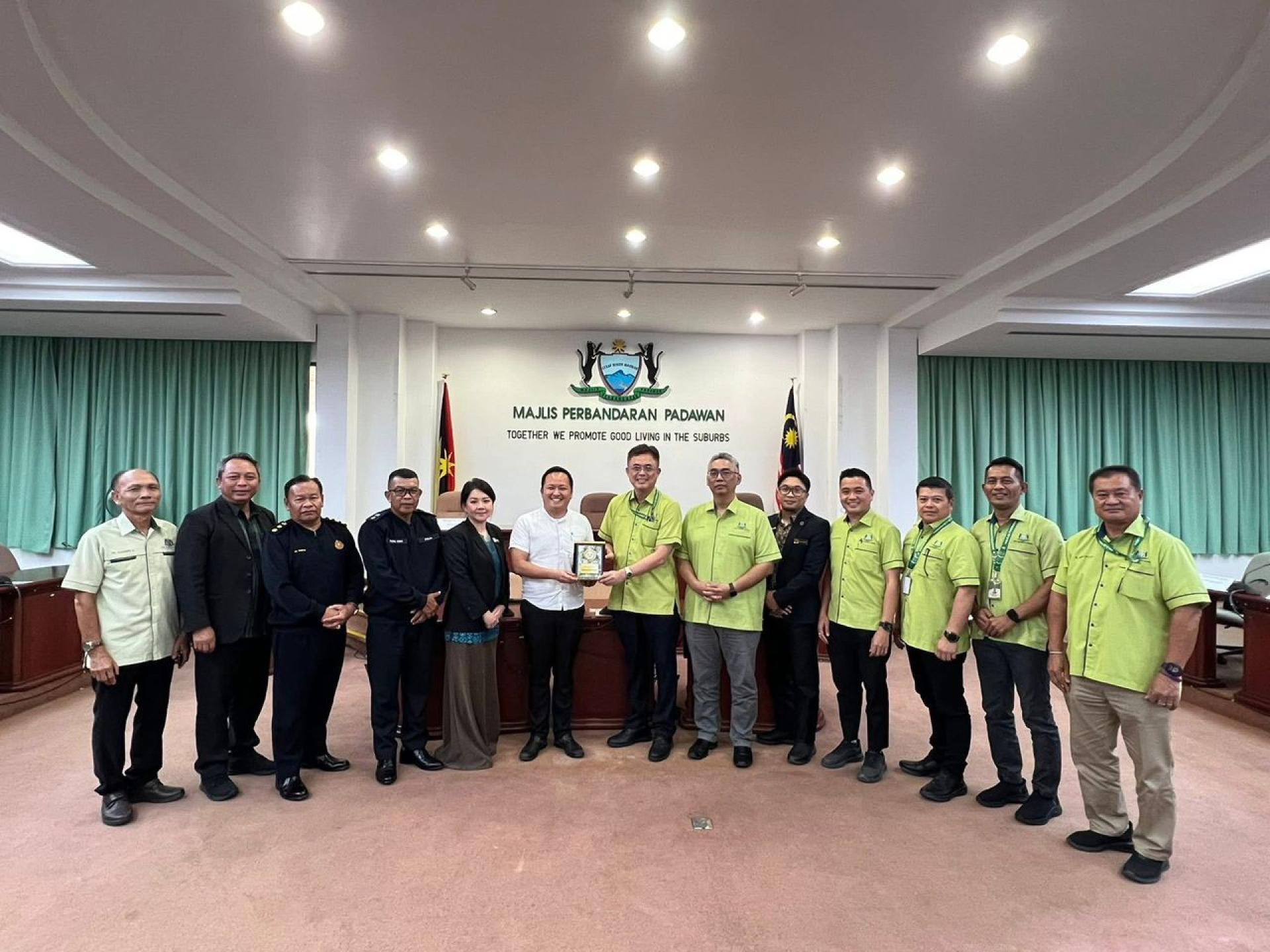 砂商用车辆注册局主席江峰年（左6）与巴达旺市议会主席陈开互赠纪念品。