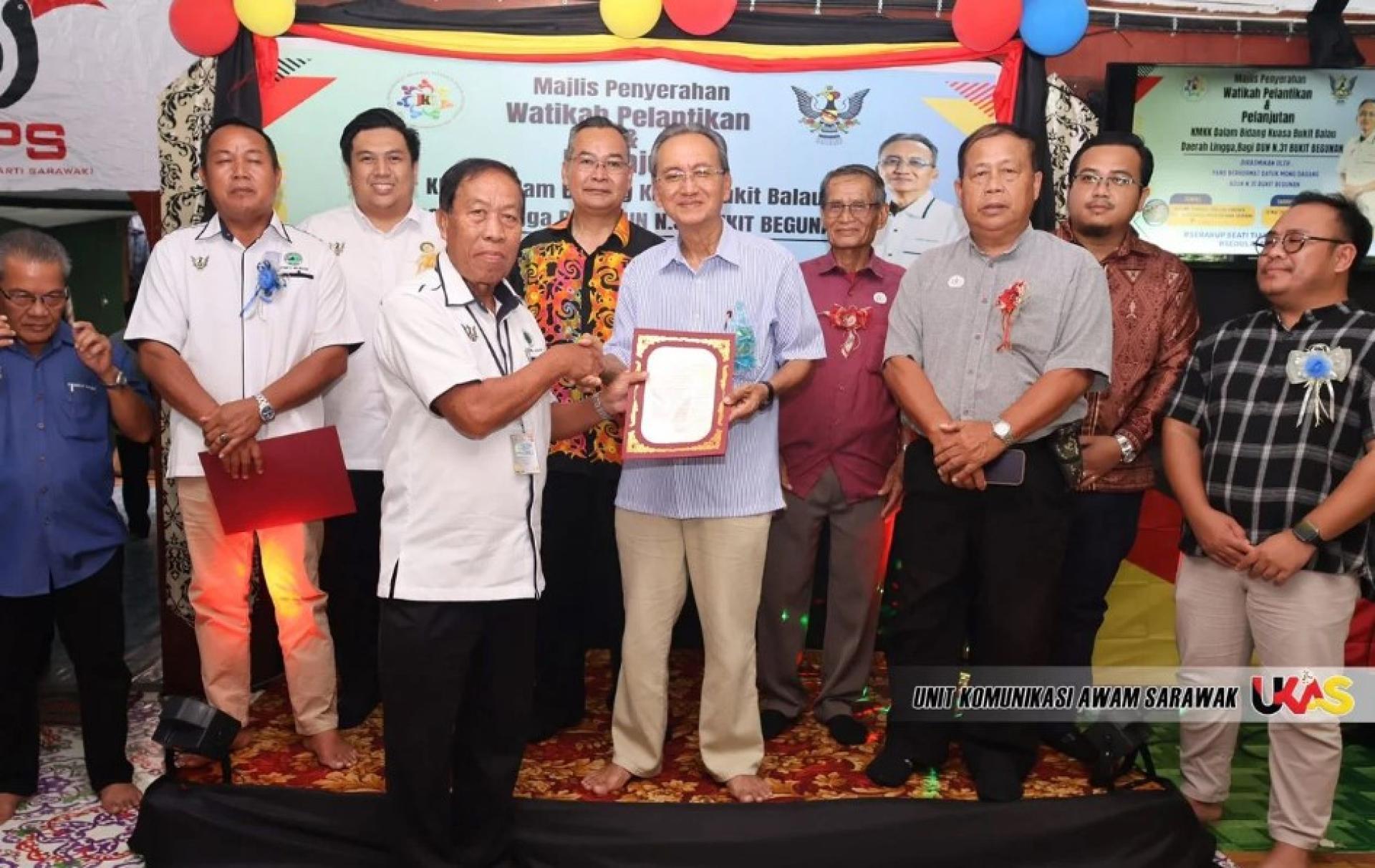 蒙达干（中）向一名受赠者颁发任命函。