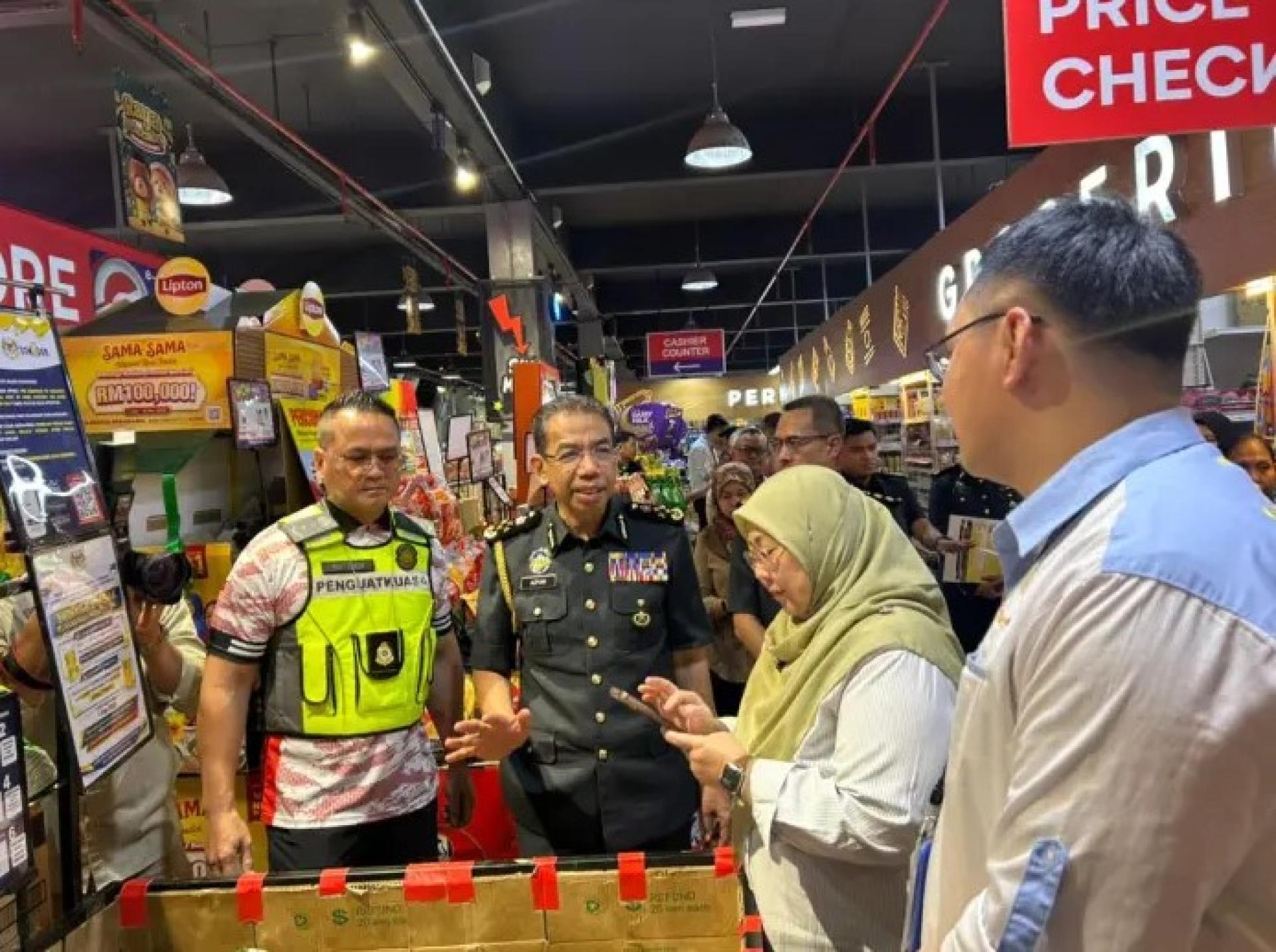 傅芝雅（右2）与（从左起）马修、阿兹曼及Ngu Ting Sii于2026年3月13日在马当Emart检查食用油包装。