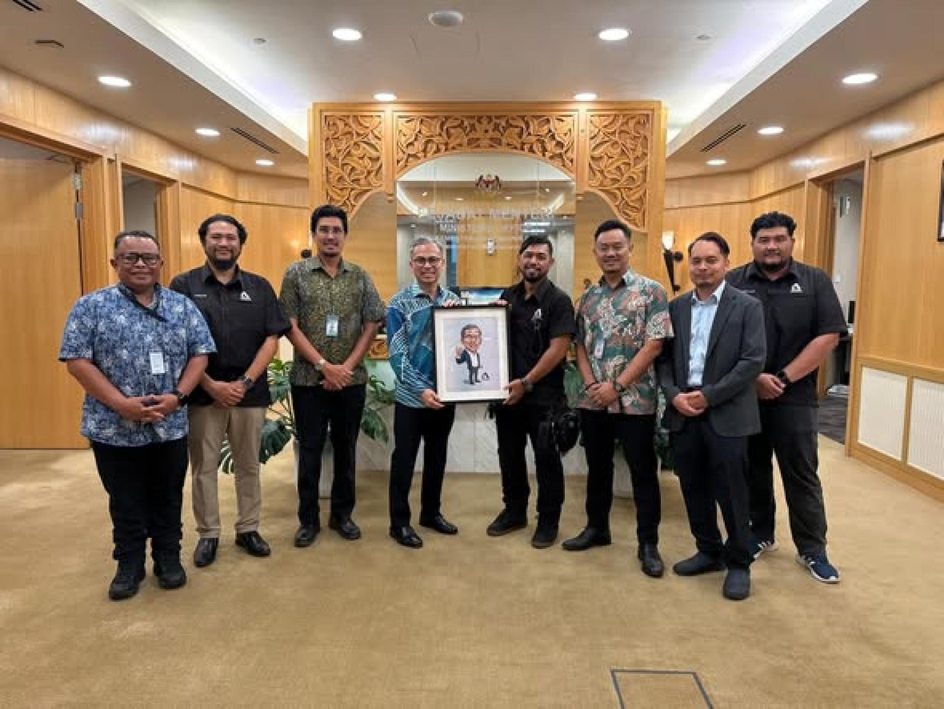 FINAS与马来西亚动画协会代表拜访法米（左4），探讨动画业者当前面临的问题。代表们也送上一幅法米的卡通画像纪念品。