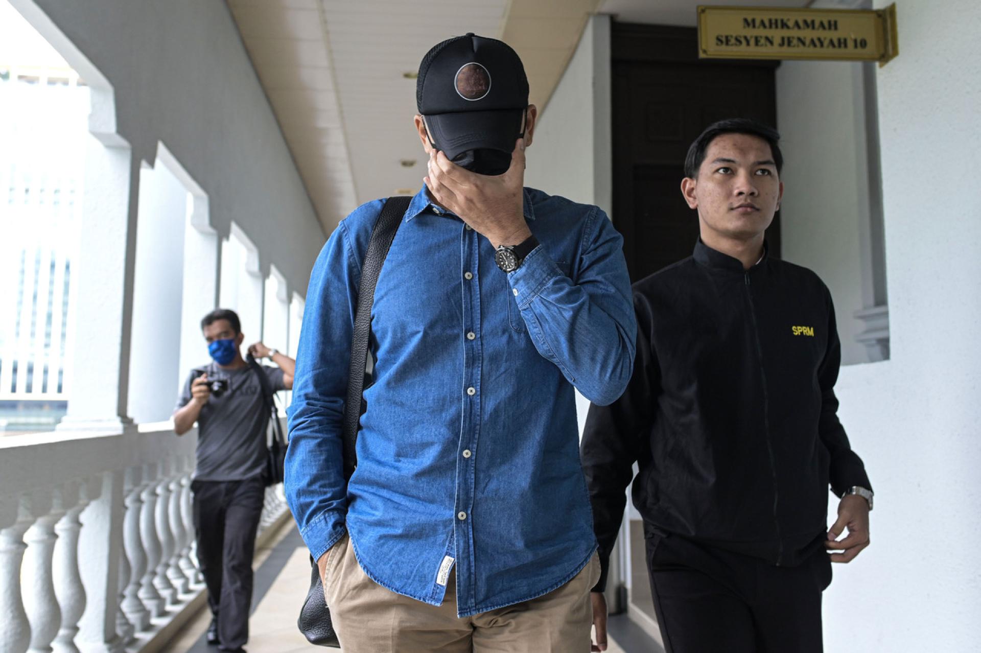 古再里（中）周五在莎阿南地庭面控，他聆听法官阿旺克里斯纳达宣读控状后，当庭表明不认罪。（档案照）