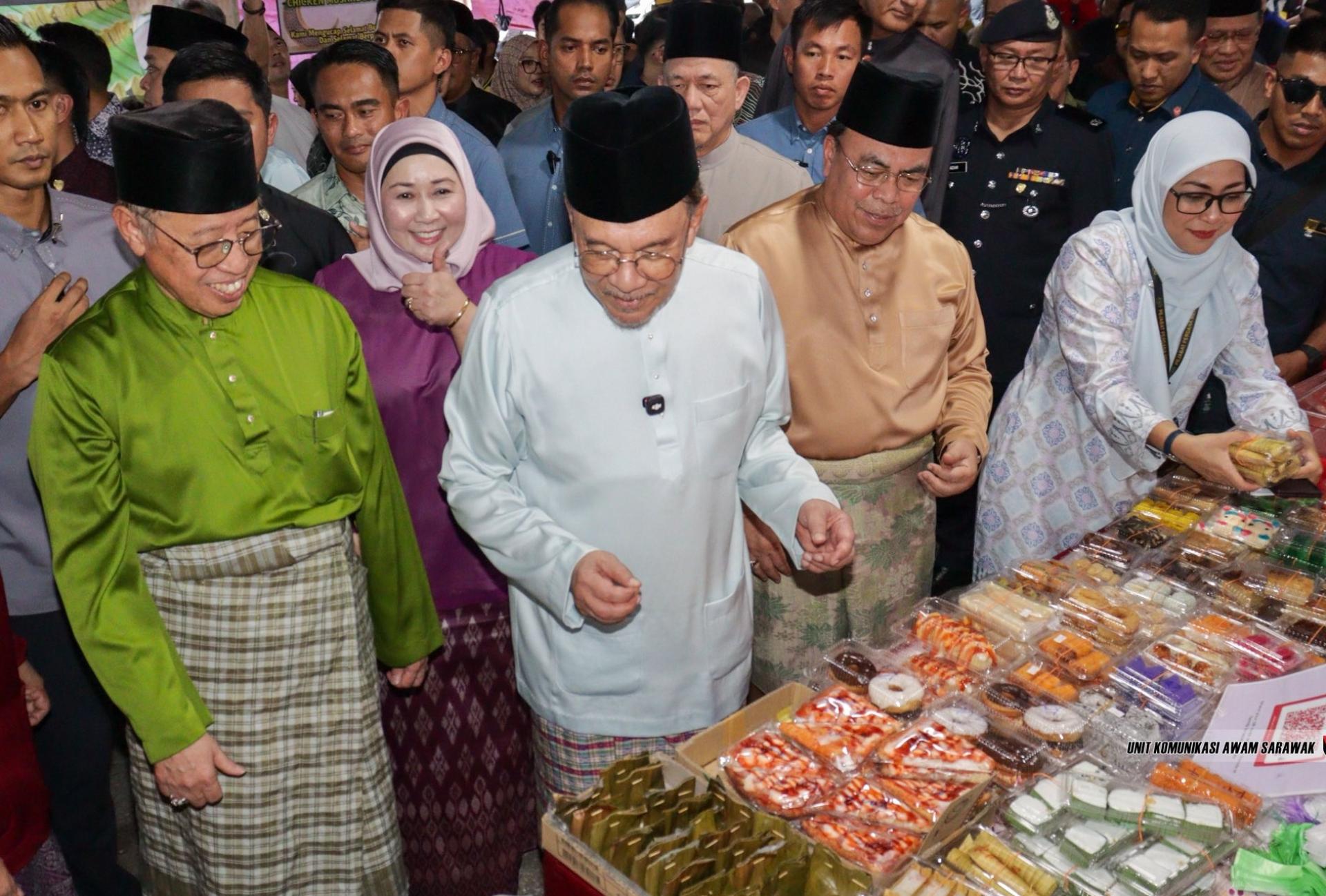 首相拿督斯里安华（左2）被林玲满目的食物所吸引。左为砂总理阿邦佐哈里。