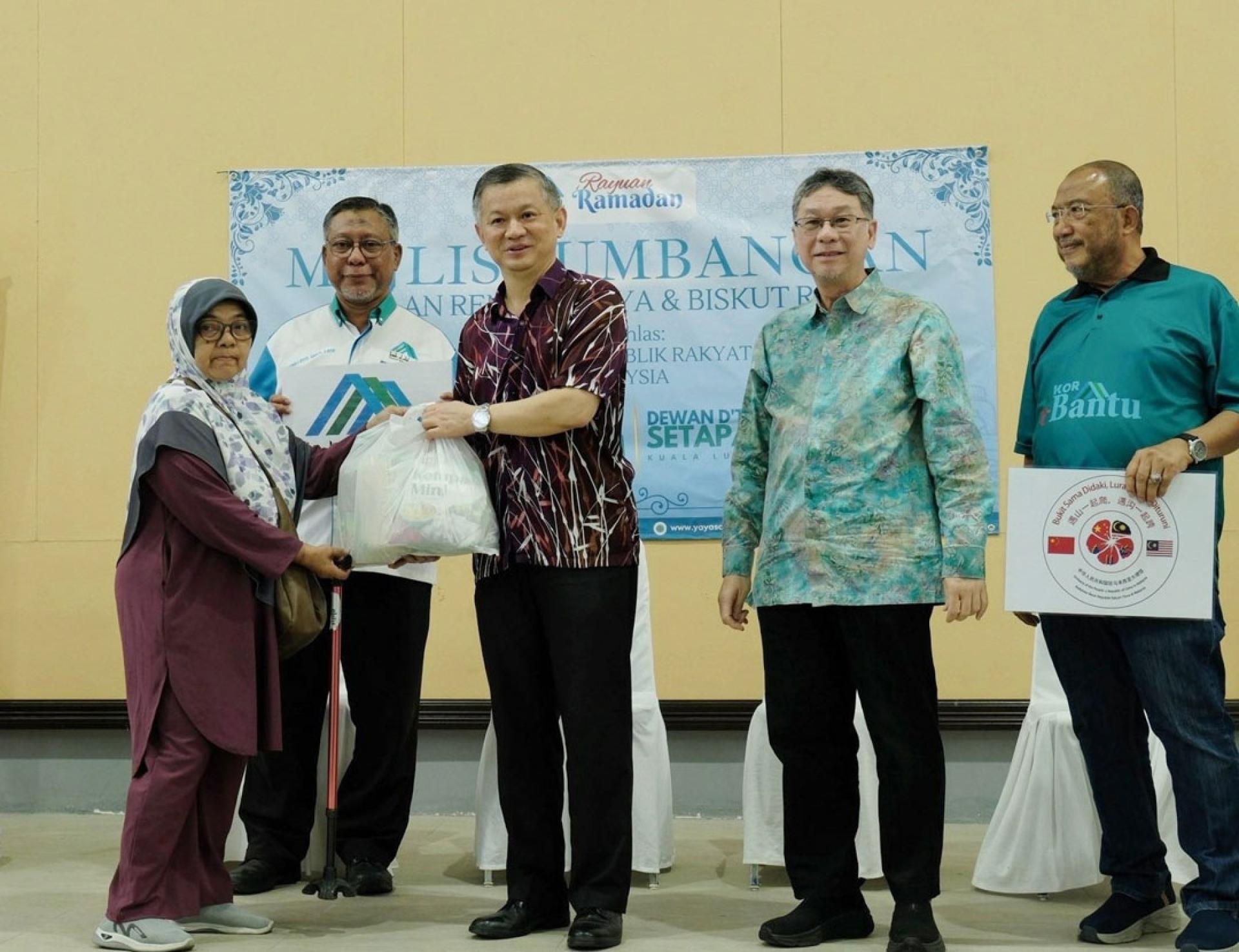 郑学方（中）颁赠斋月食品包予穆斯林民众，右2为巴德利沙；左2为艾努洛特菲。