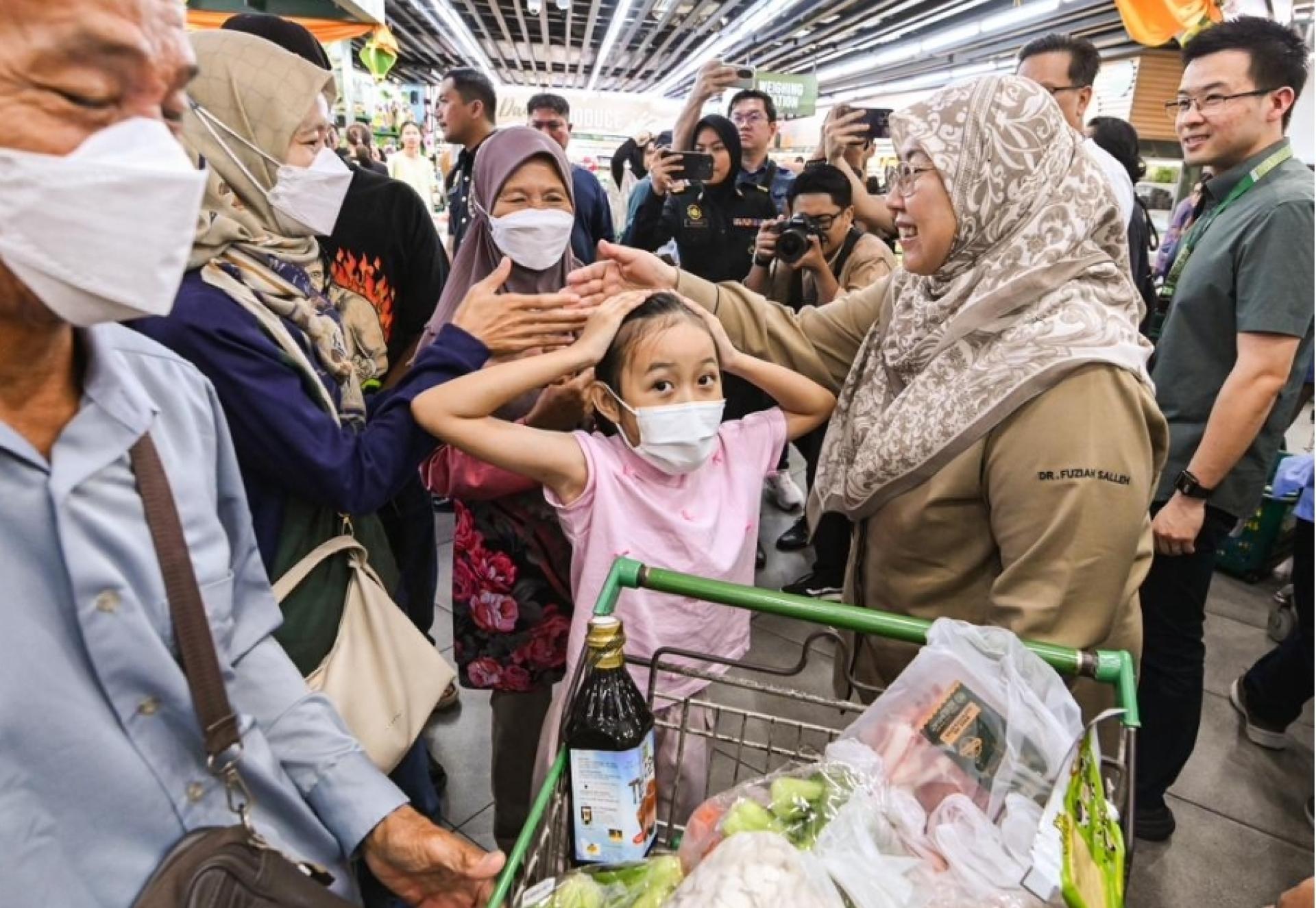 拿督傅芝雅向购物的民众寒暄交流。