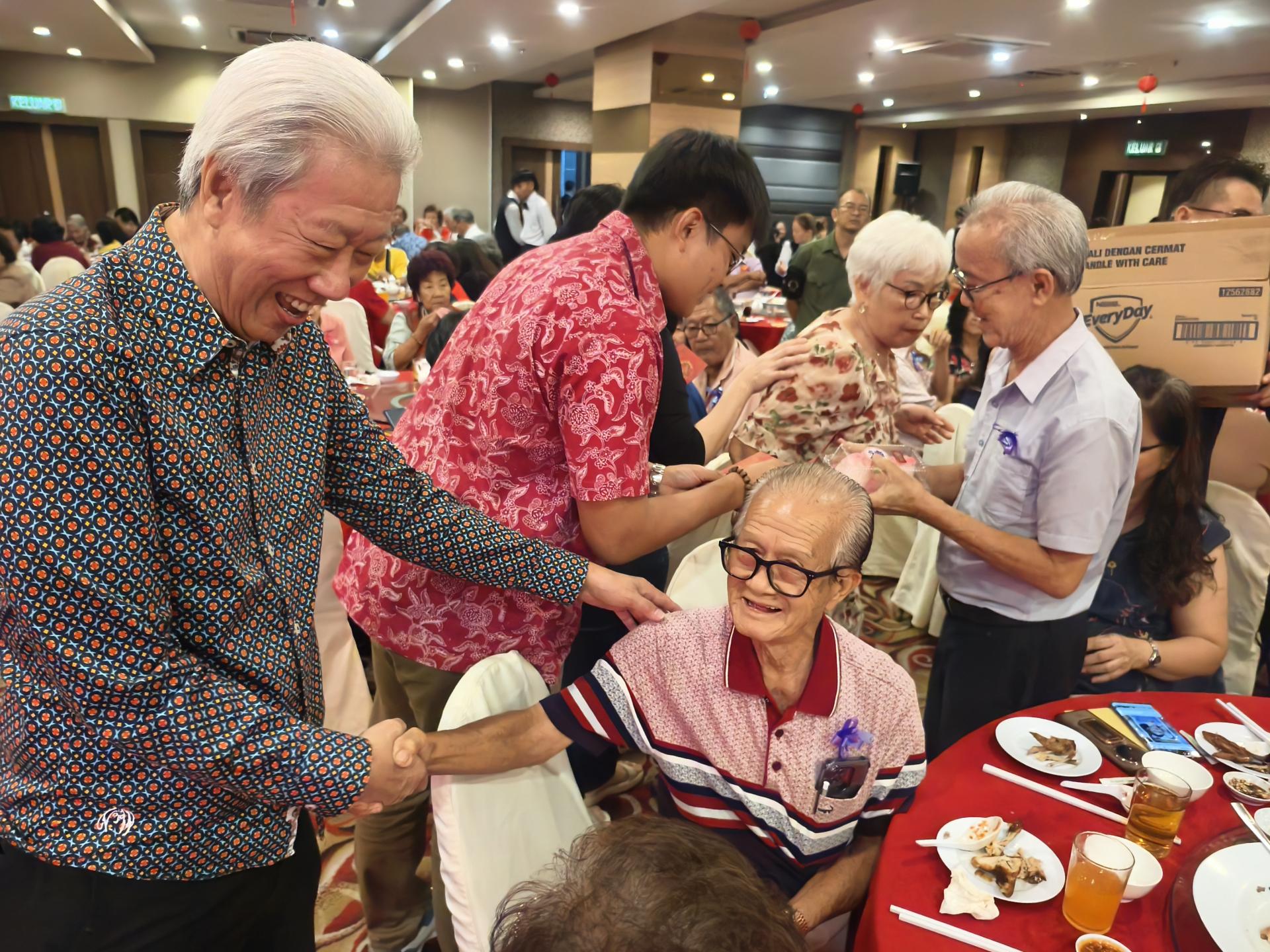 分发红包与寿桃给70岁以上德兄德姐。左起为阁长贝清湛陪同主宾的代表谢家洪与筹备会主席陈兰芳。