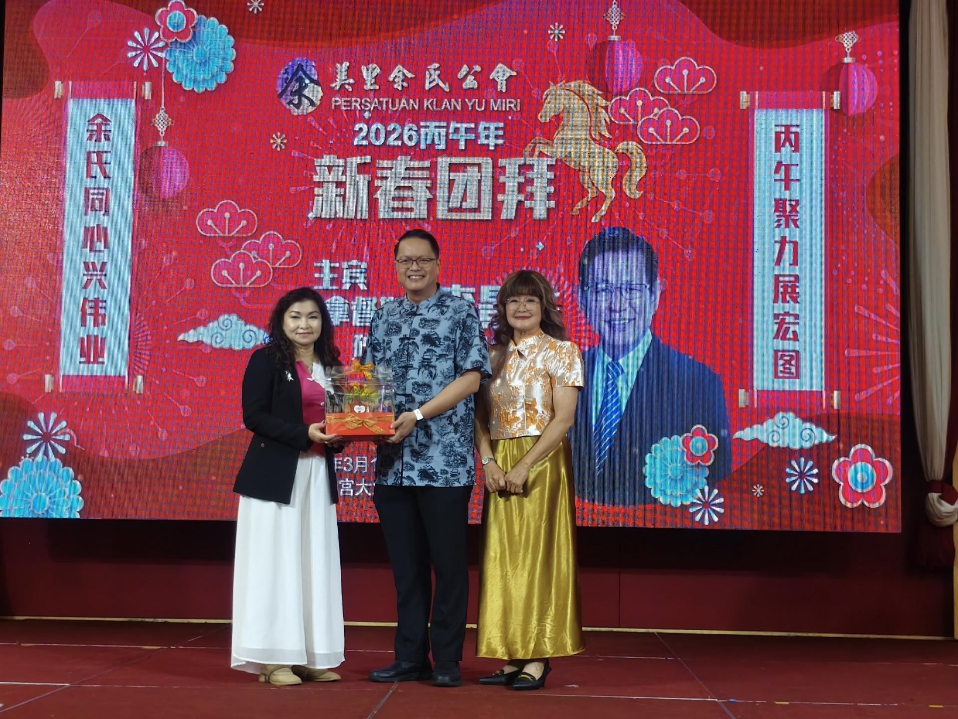 筹备会主席余明燕（左）赠送纪念品给主宾砂拉越交通部长拿督斯里李景胜的代表彭小菶。右为会长甲必丹余继香。