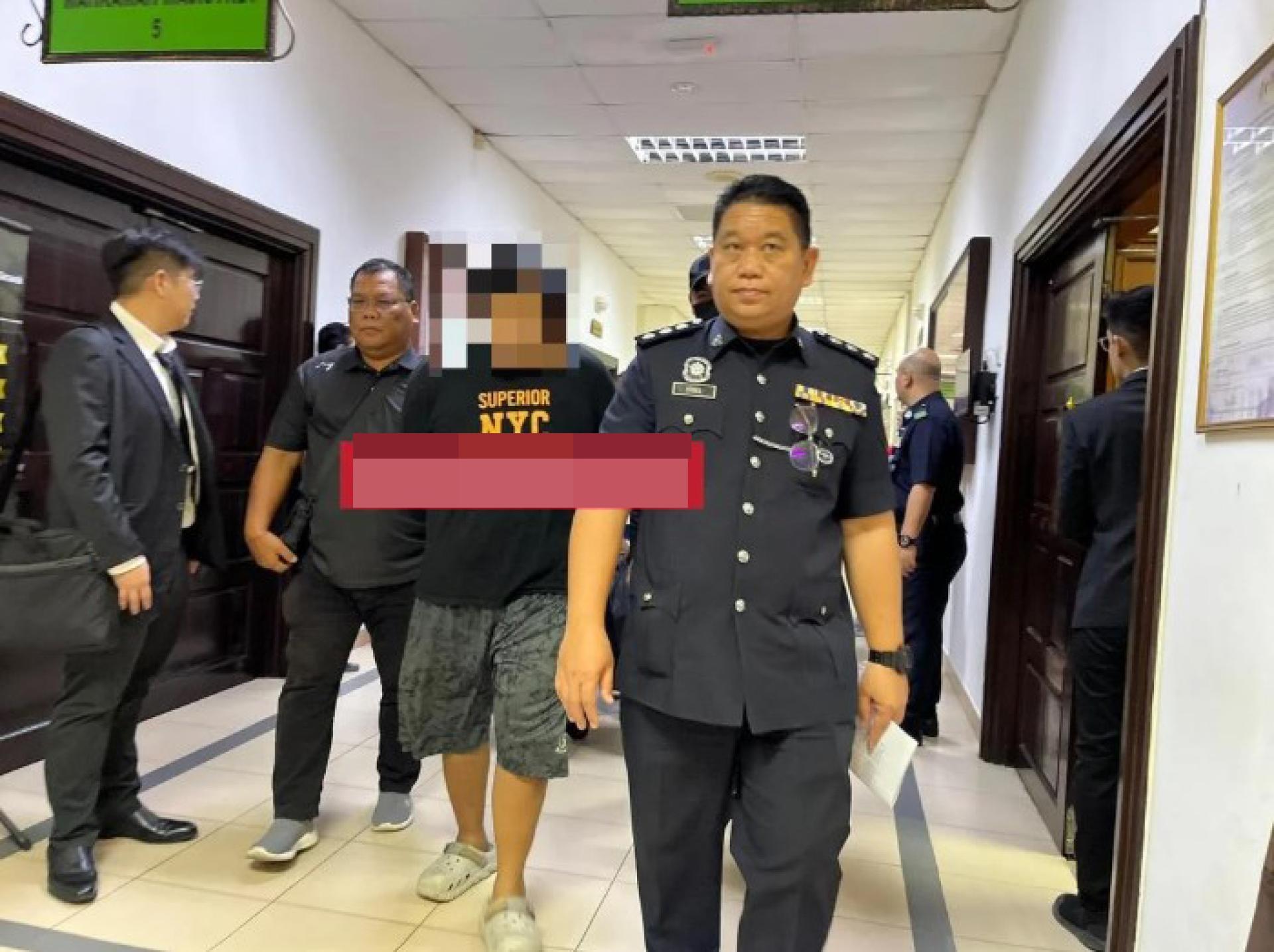 被告（中，黑衣）由警员押送出地方法院法庭。