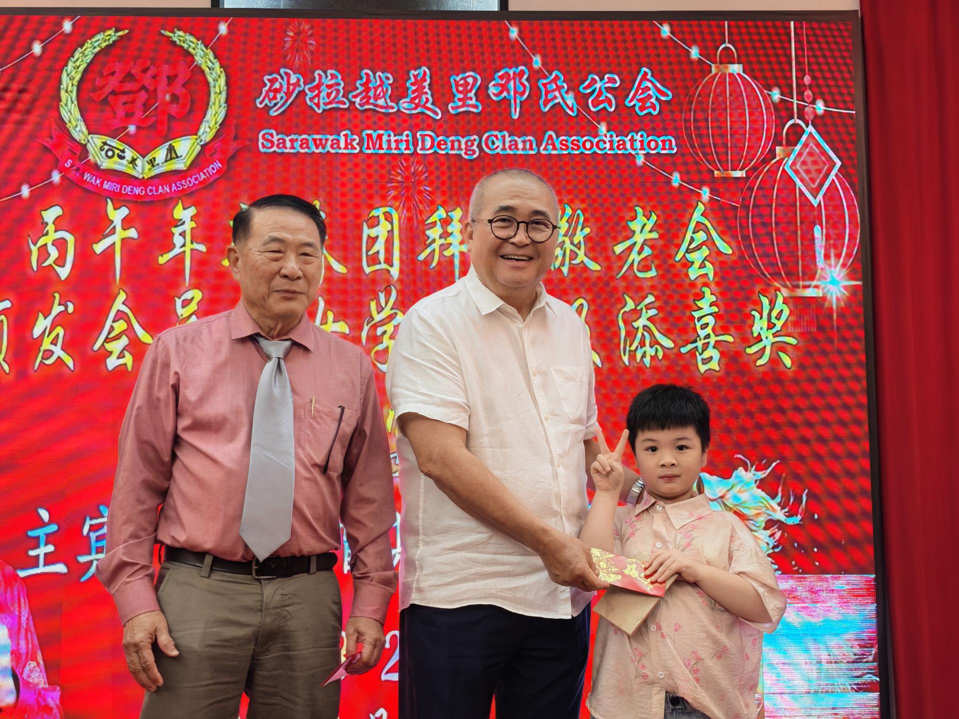 美里市长俞小珊（左2）颁发幸运红包给得奖者。左为砂  拉越美里邓氏公会会长邓敦明。
