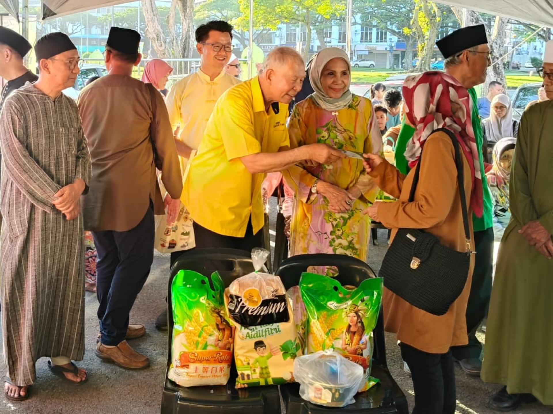 砂旅游部副部长拿督陈超耀（左）移交物资及青包予一名受惠者。