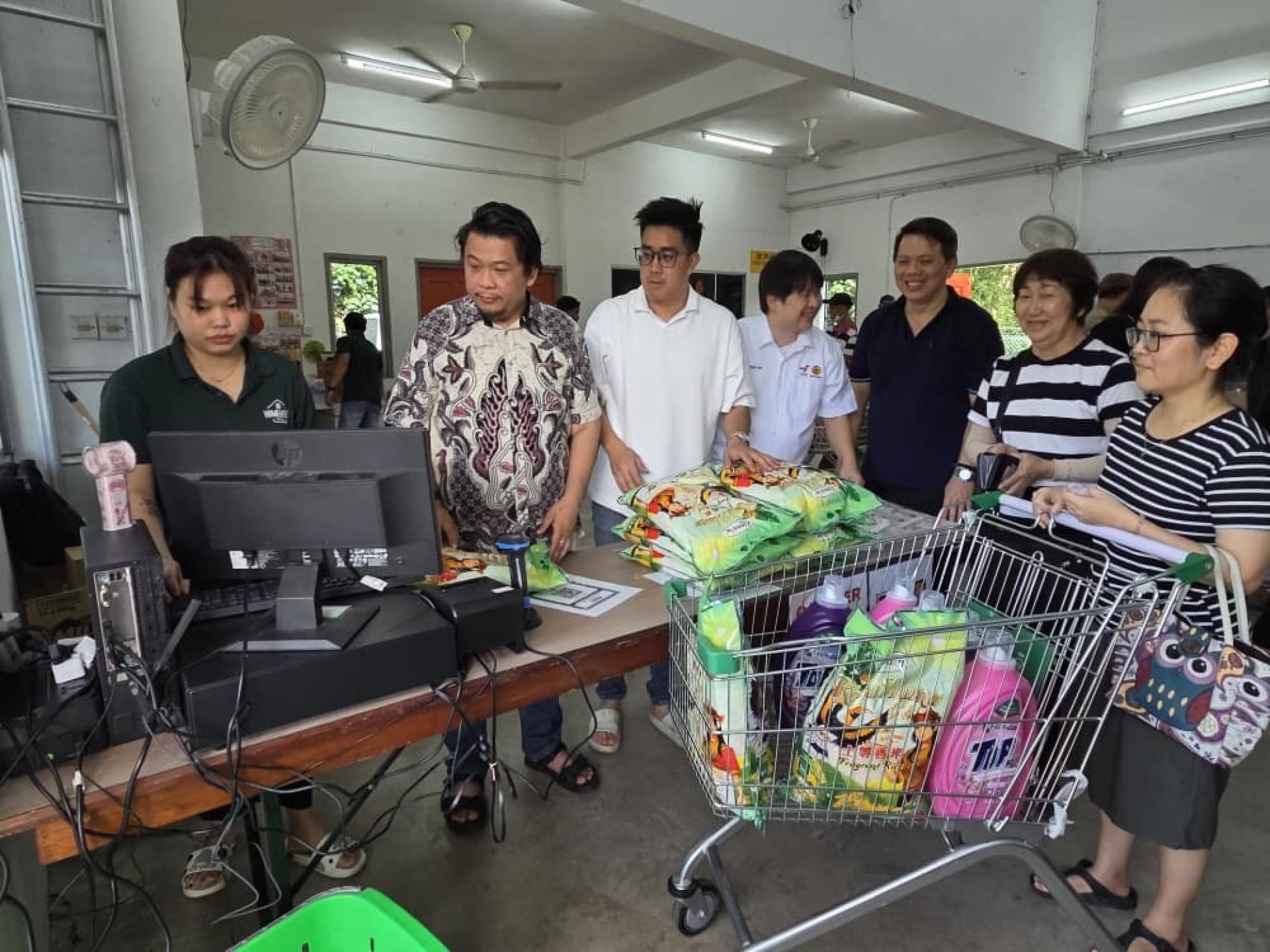 鲁卡尼斯曼（左2）巡视“昌明爱心促销”活动。