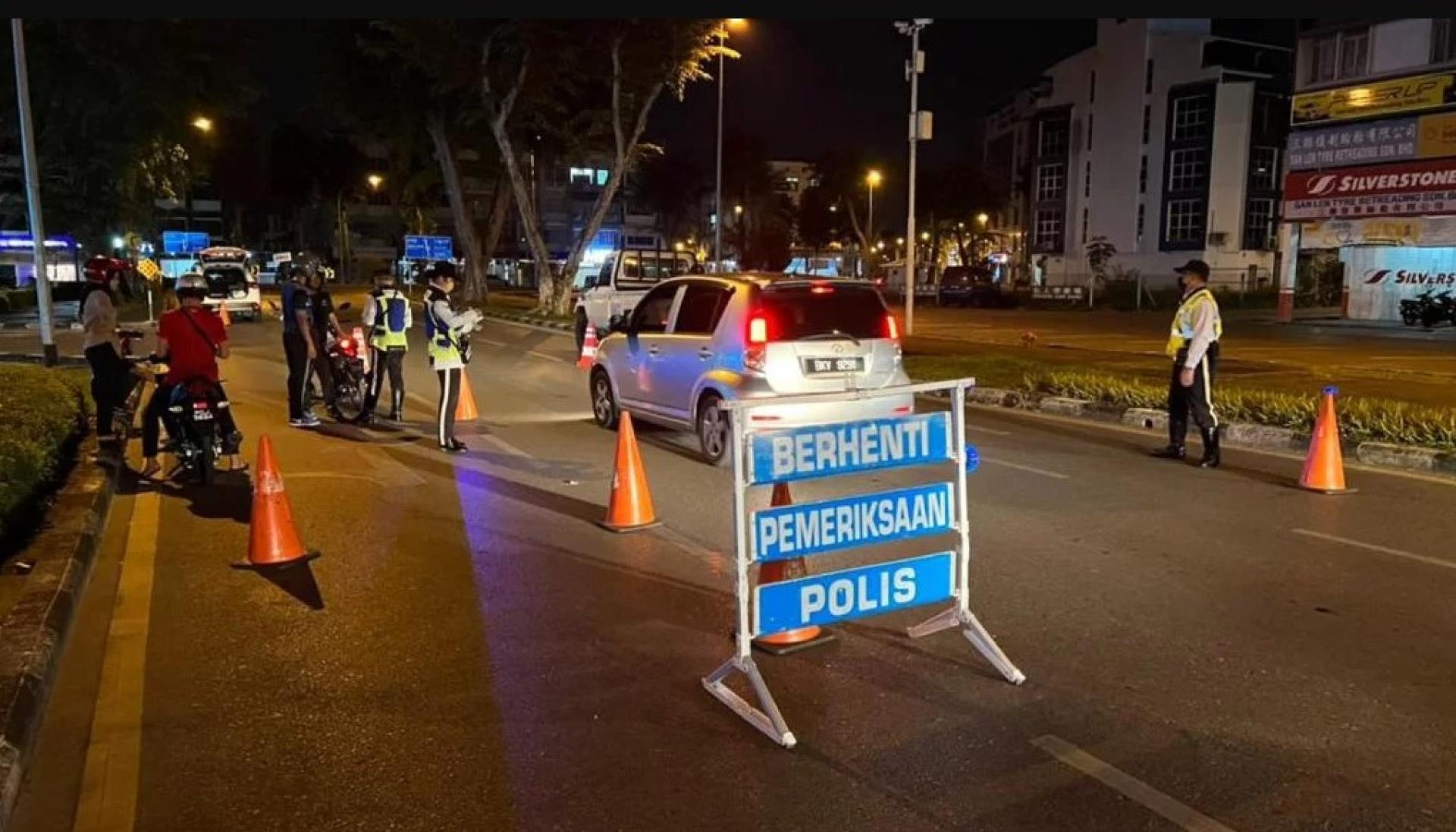 警方在路障检查站拦截车辆及摩托车进行检查。（档案照）