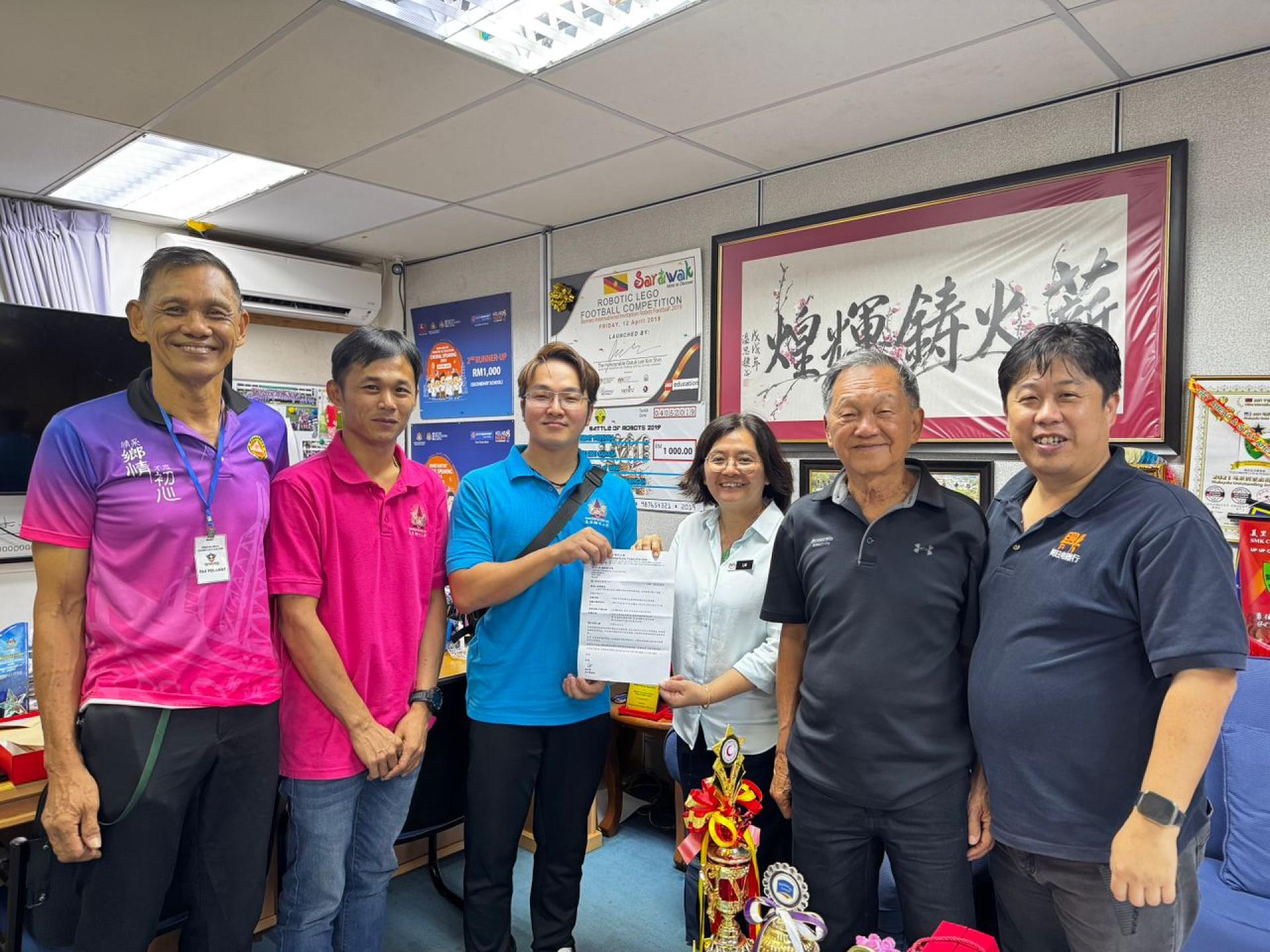 主办方移交场地使用函予美里中华中学。左起为美里潮州公会主席杨振平，青年团团长吴洪庆，筹备会主席姚宜松，校长赖佳玲，公会副主席林荣书及宣传佘世综。