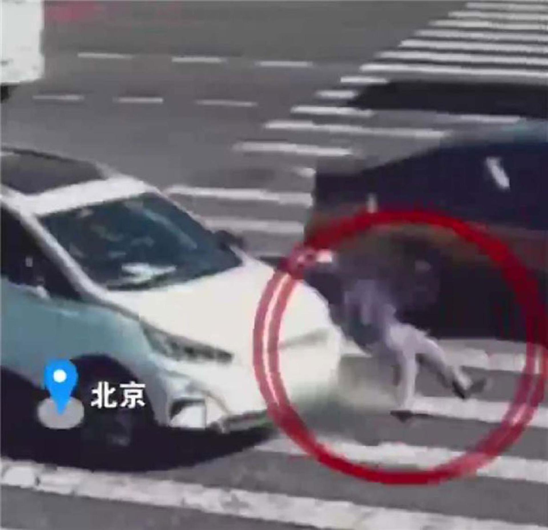 一名89岁老人过马路半路变红灯，被转弯的白色私家车撞倒。