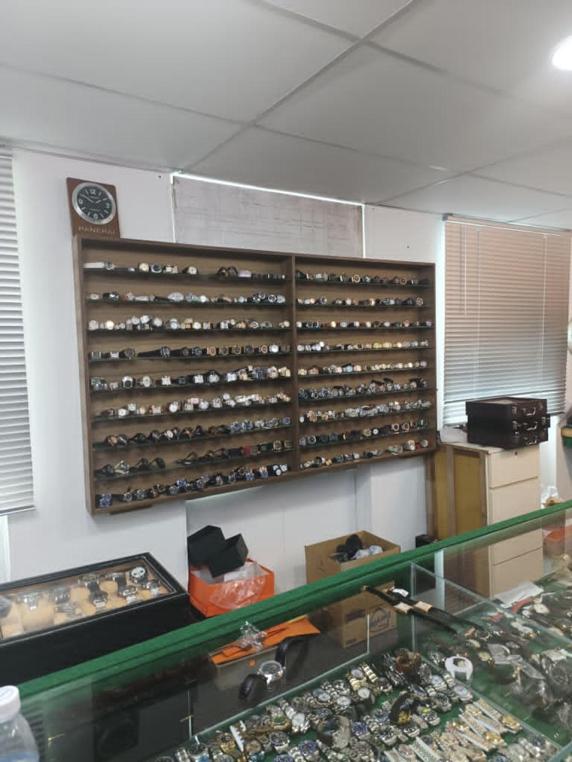 陈列架和柜子内的各品牌手表，疑似冒牌货。