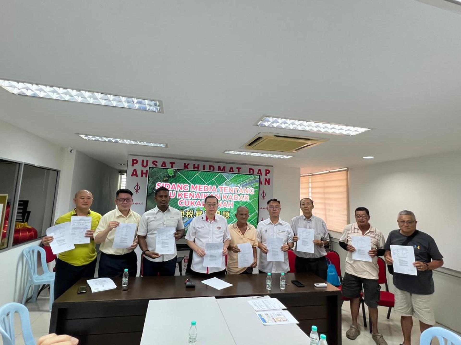 北海惹兰拉也乌达商业中心（廉价屋）地税骤降8０%，林冠英、朱悦权、古玛兰克里斯南、黄伟益等，与管理委会主席王乃庄、负责人姚友成及居民展示新的地契的新地税款项。