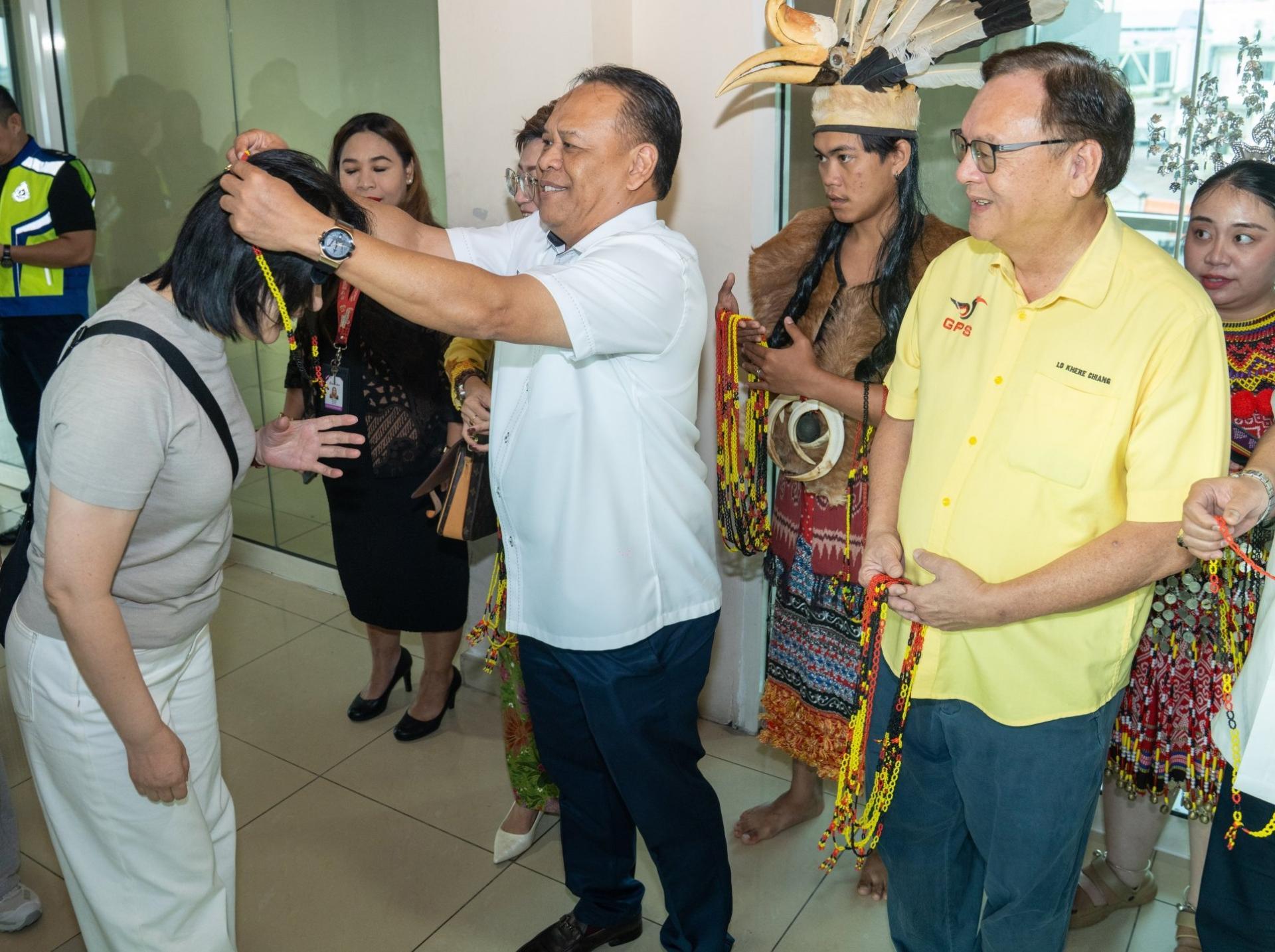 砂交通部副部长拿督亨利吉纳（中）代表交通部欢迎从广州抵达古晋的包机乘客。其右为拿督罗克强。