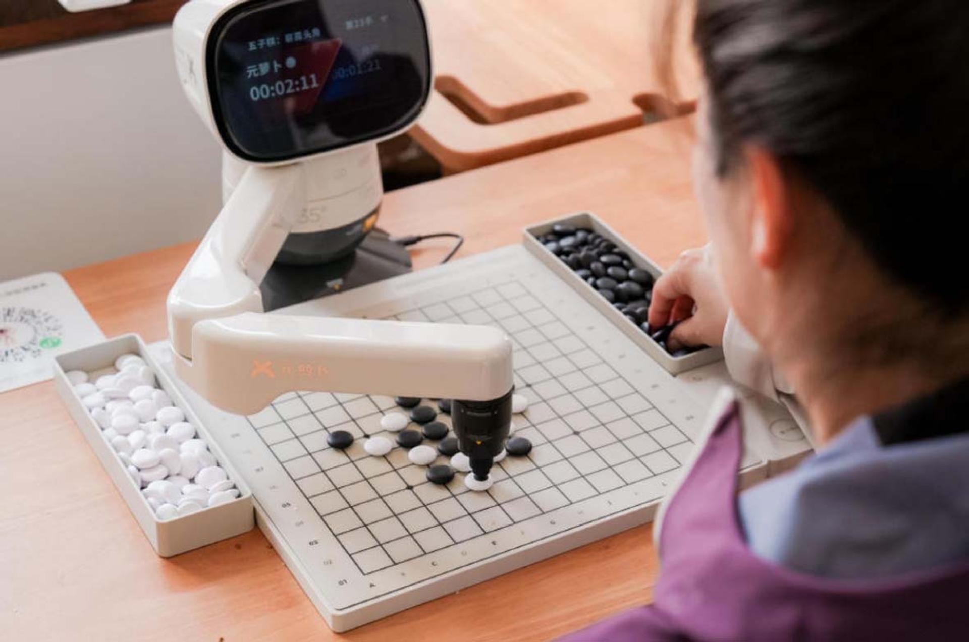 一名长者与机械人下围棋。