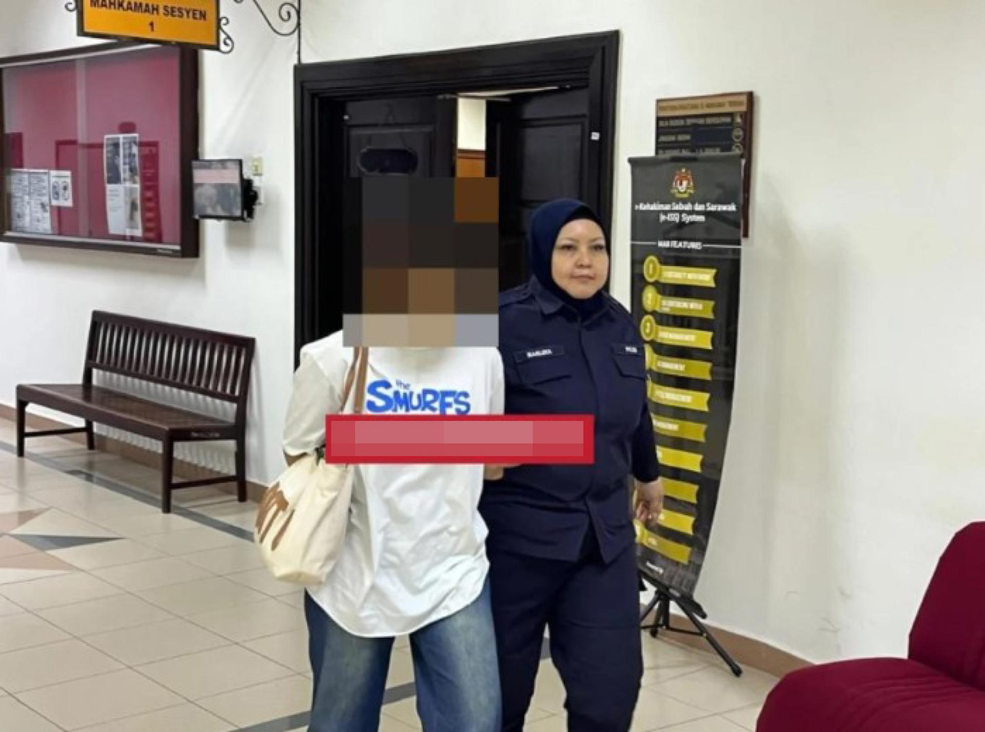 穿白色衣服的被告在庭审结束后由女性警员带出第一地方法院。