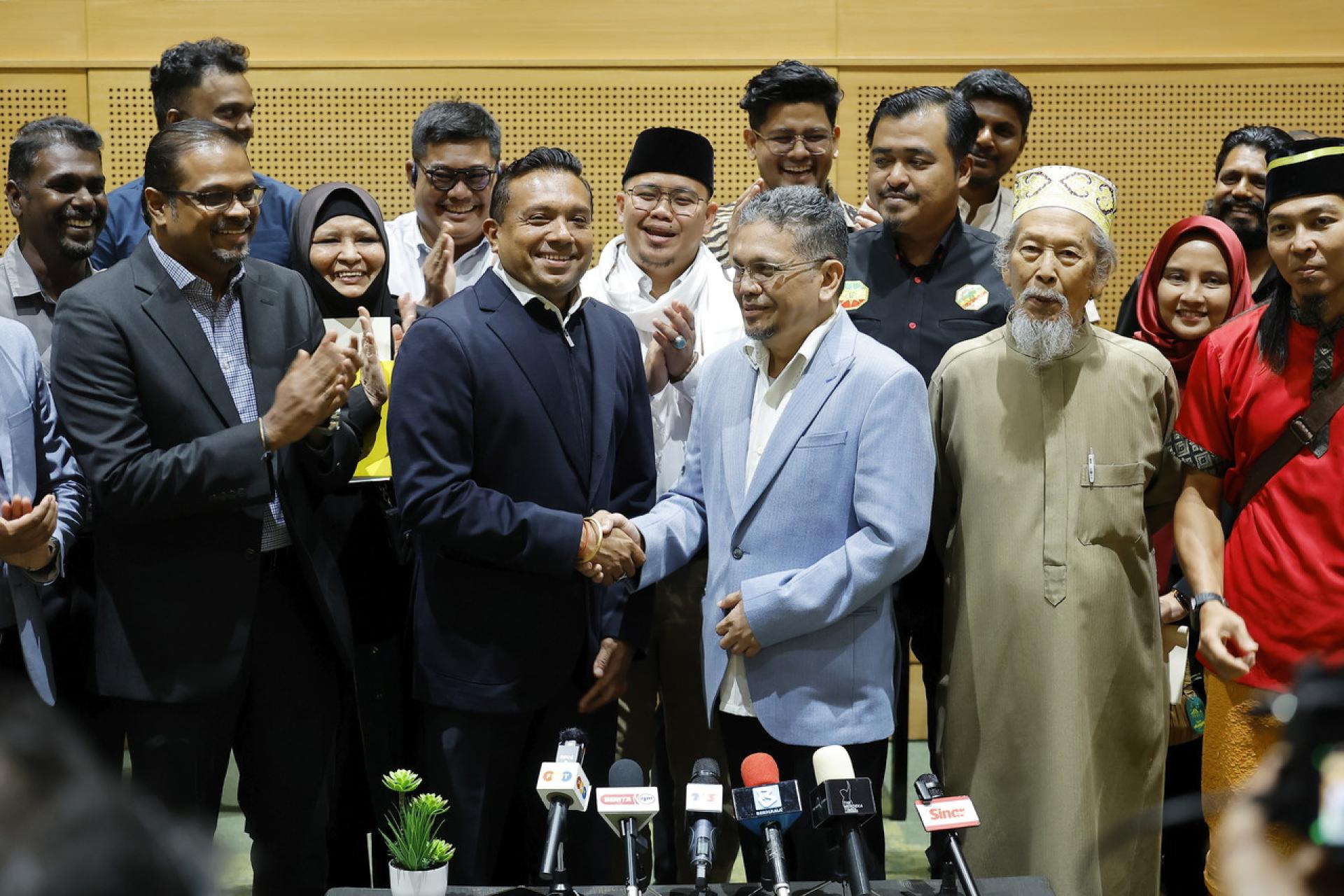 再努利加与西华古玛在“昌明和谐”活动后召开的新闻发布会上，握手致意。