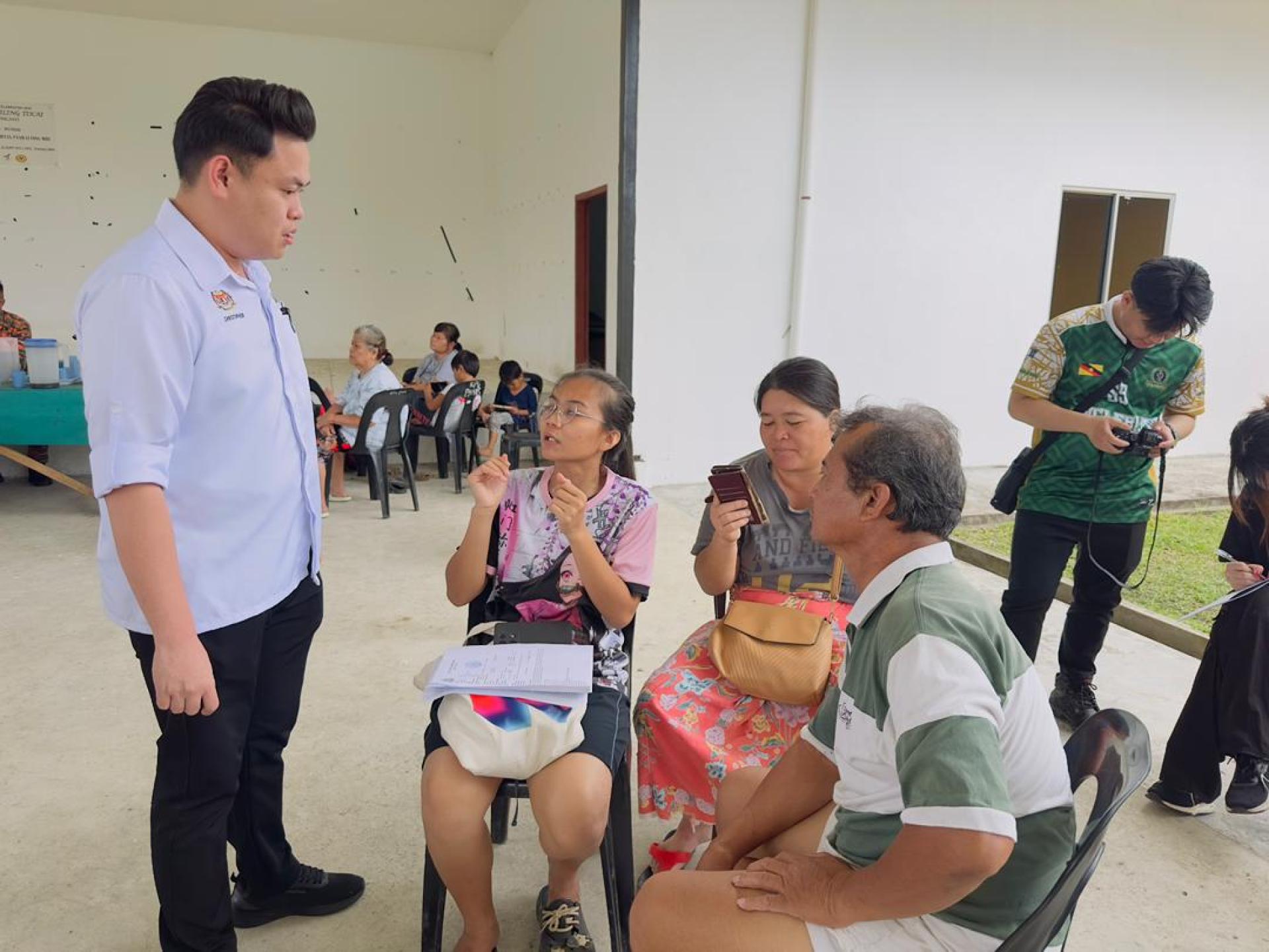 克里斯多福（左）亲切慰问灾黎，了解他们的实际需求。