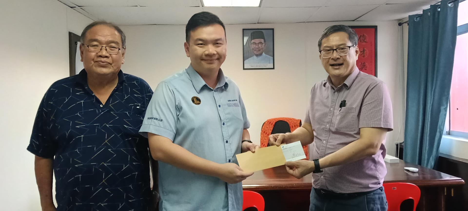 罗东华小董事长江山河（右1）从赵俊文手中接过拨款时摄。左1为董事财政方孝秀。