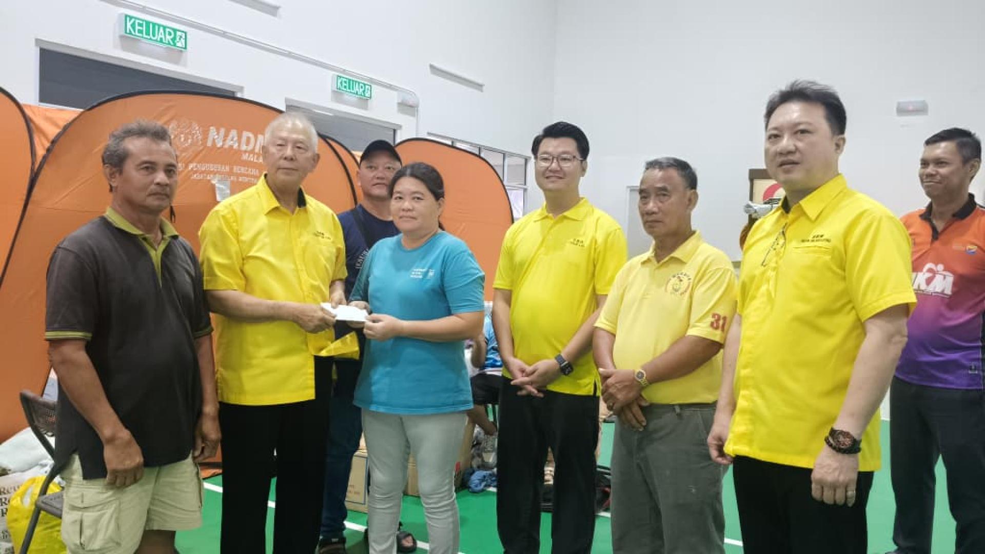 拿督陈超耀（左2）将援助金移交予其中一户家庭。