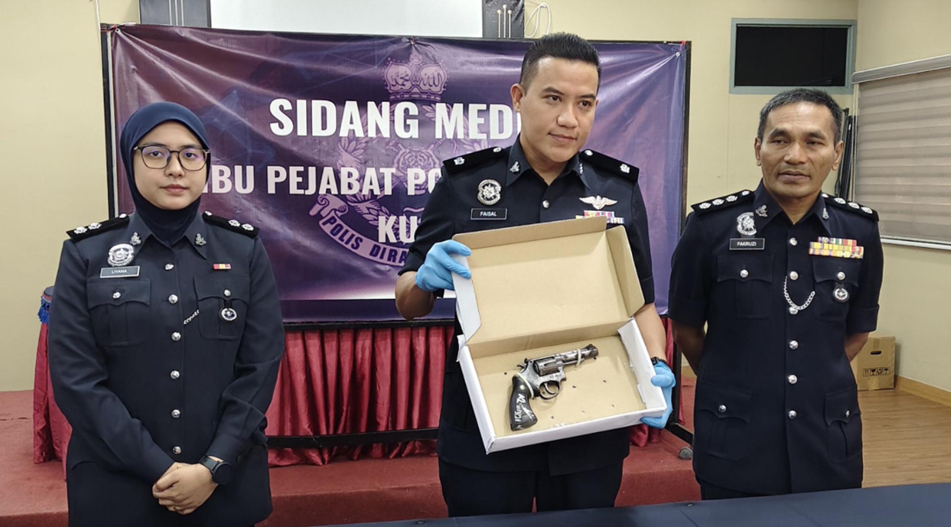 法依沙（中）向媒体展示起获的枪支；左起为努莉亚娜及法库鲁斯。