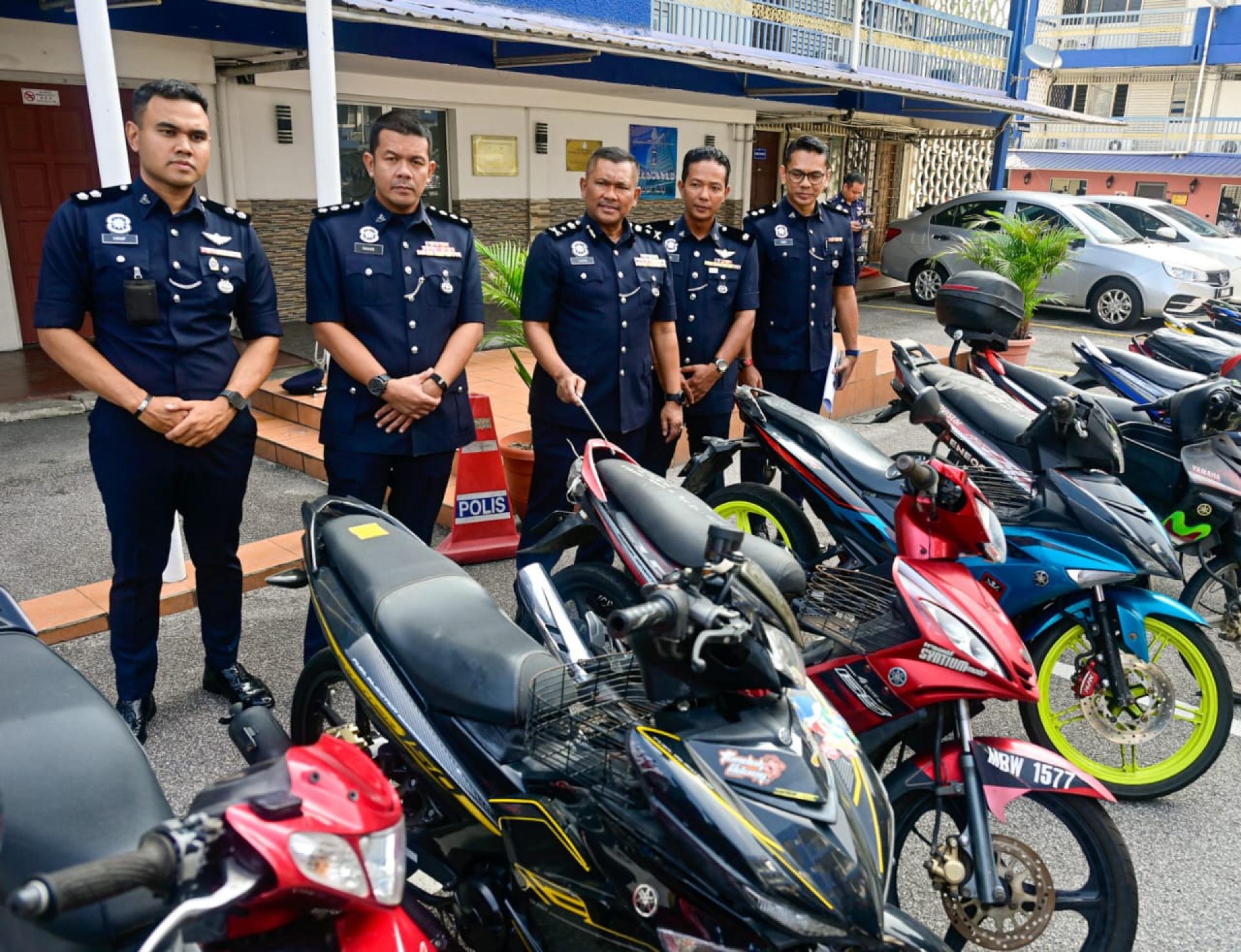 拉欣（中）向媒体出示搜到的部分报失摩托车。