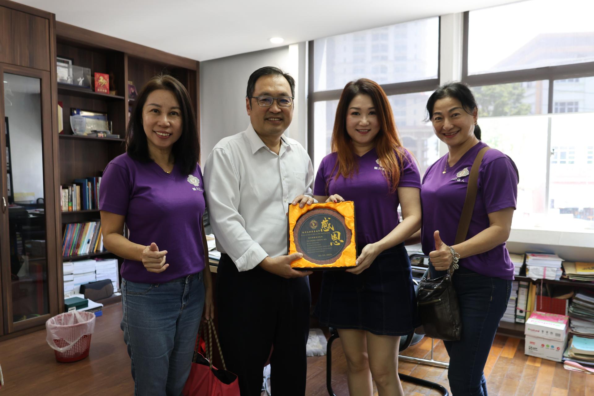 黄伟緧（右2）在副会长沈惠香（左1）及秘书陈亿（右1）的陪同下，赠送纪念牌予张健仁。