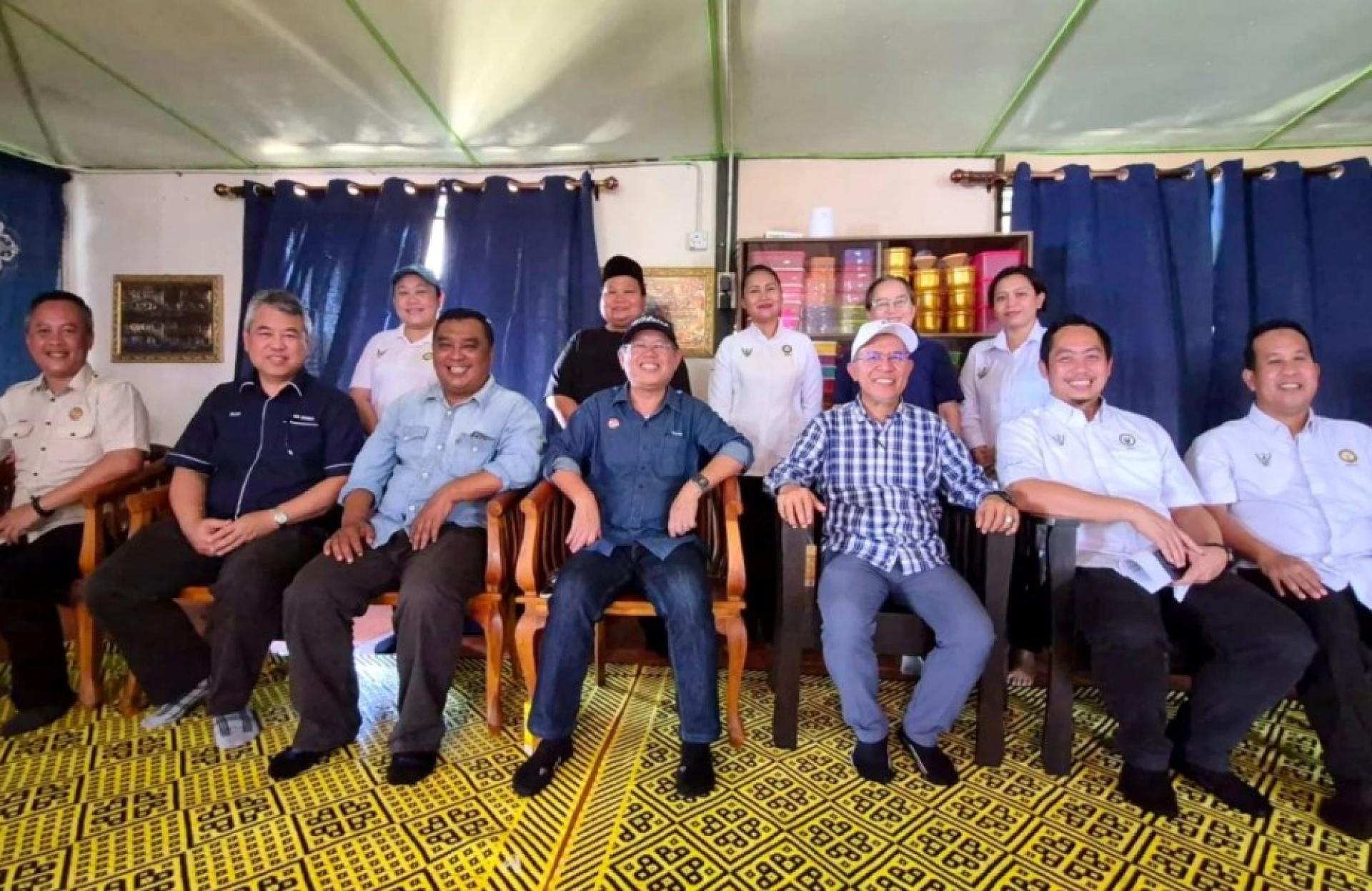 马丁本与莫哈末杜里在甘榜卡巴牲畜饲料分站项目地点进行工作访问时合影。