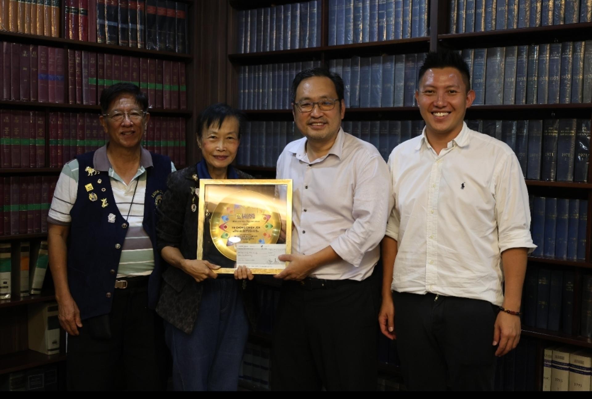 张健仁（右2）移交拨款支票后，张惠媚（左2）回赠纪念品予他。左及右分别是古晋北市狮子会会员钟约翰及张健仁特别助理沈杰龙。