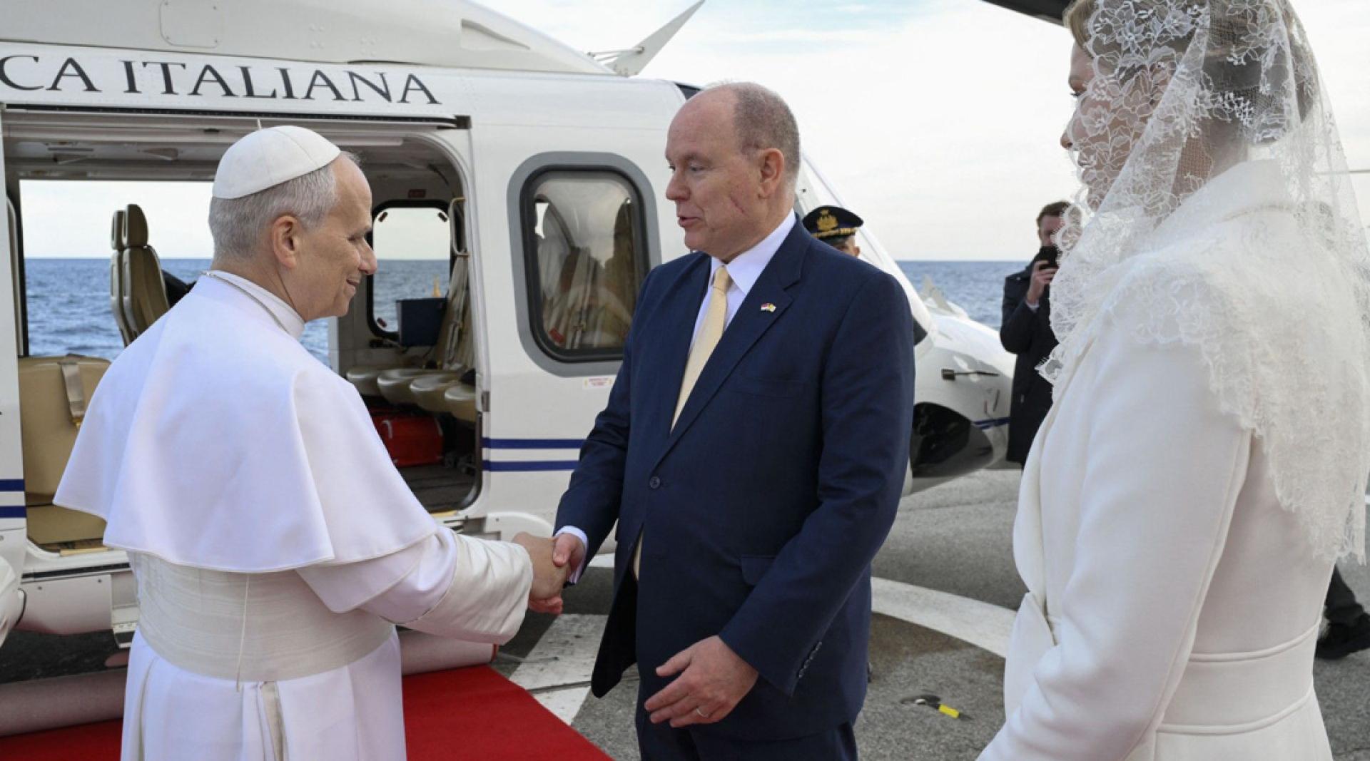 摩纳哥国王阿尔贝二世（中）和王后夏琳（右）28日护送教宗良十四世（左）从摩纳哥蒙地卡罗的直升机场登上直升机。