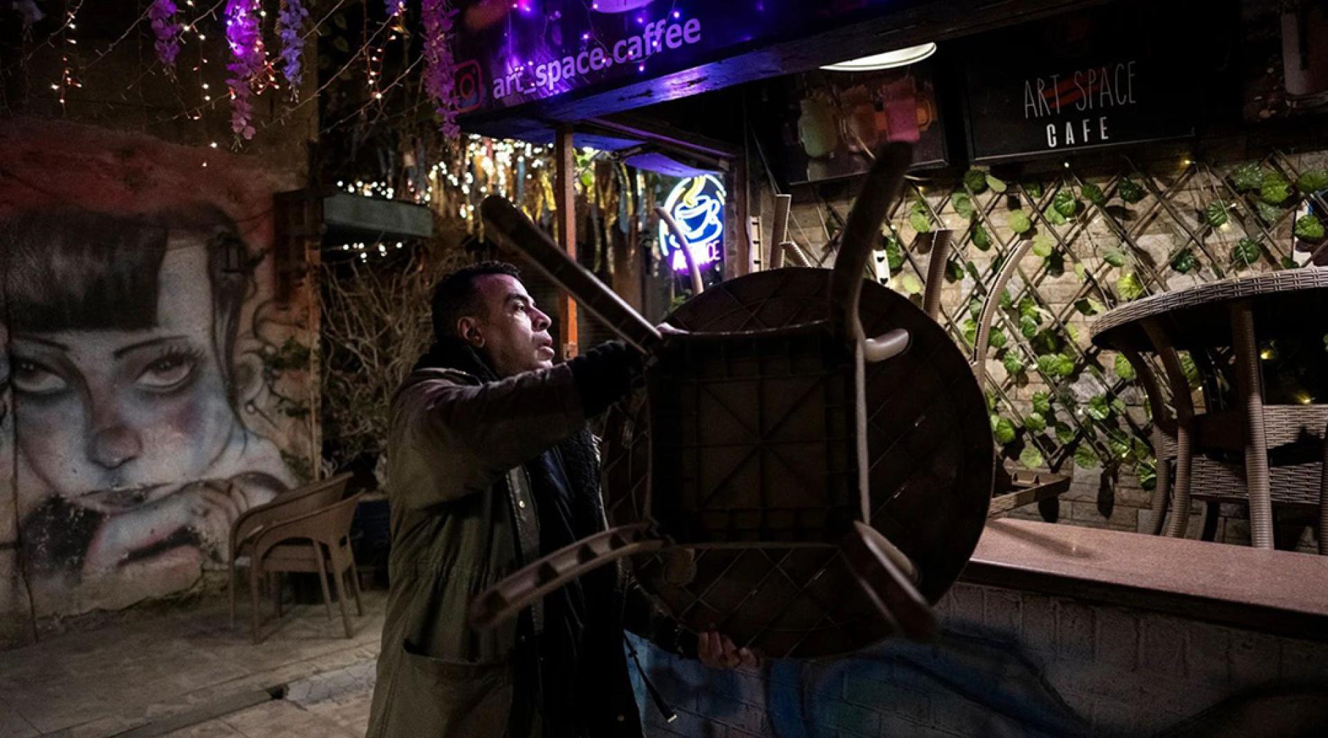 为配合政府推出节约能源措施，一名餐厅员工在晚上提早打烊。