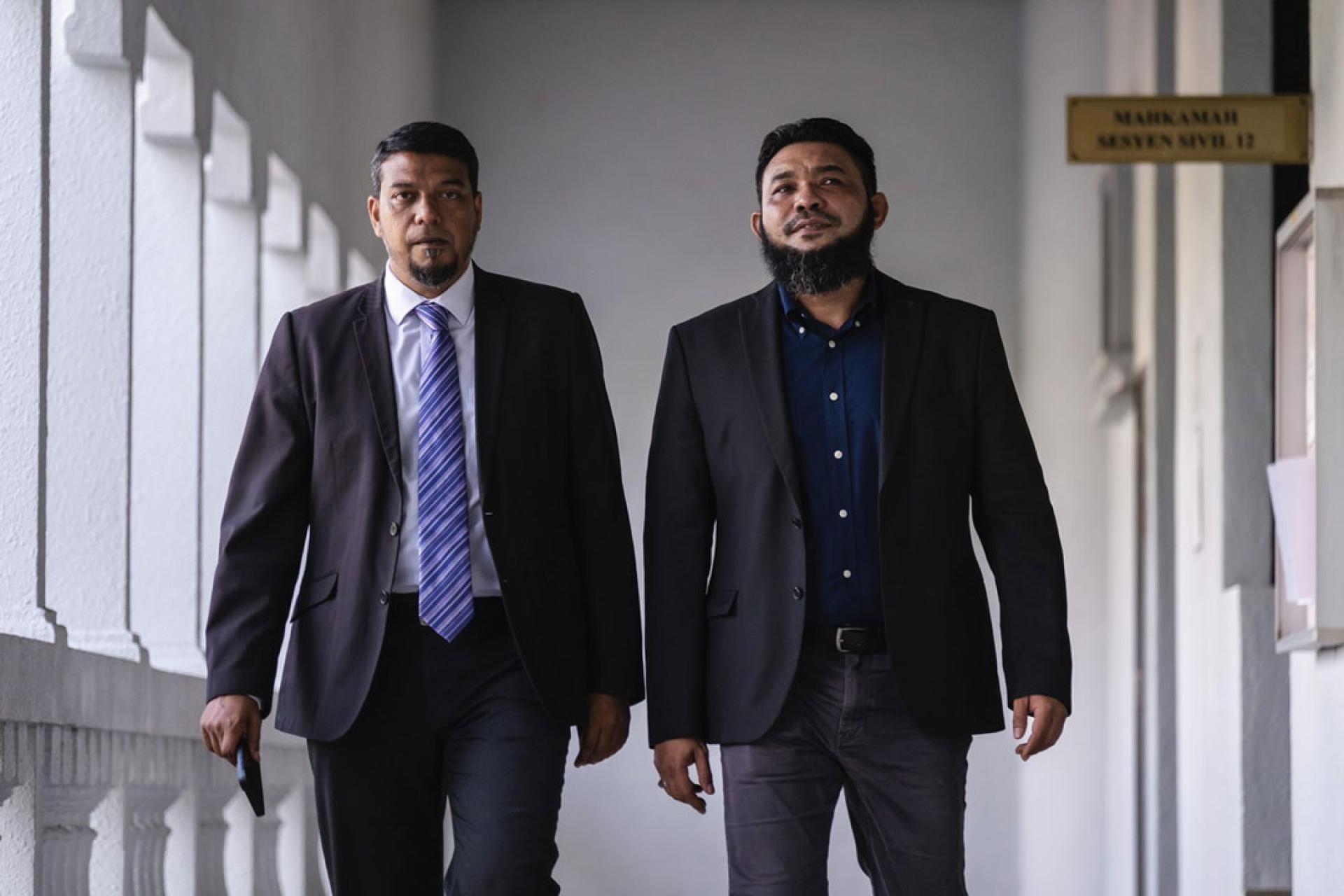 “Papagomo”旺莫哈末阿兹里（右）与律师拉菲克一同出庭。