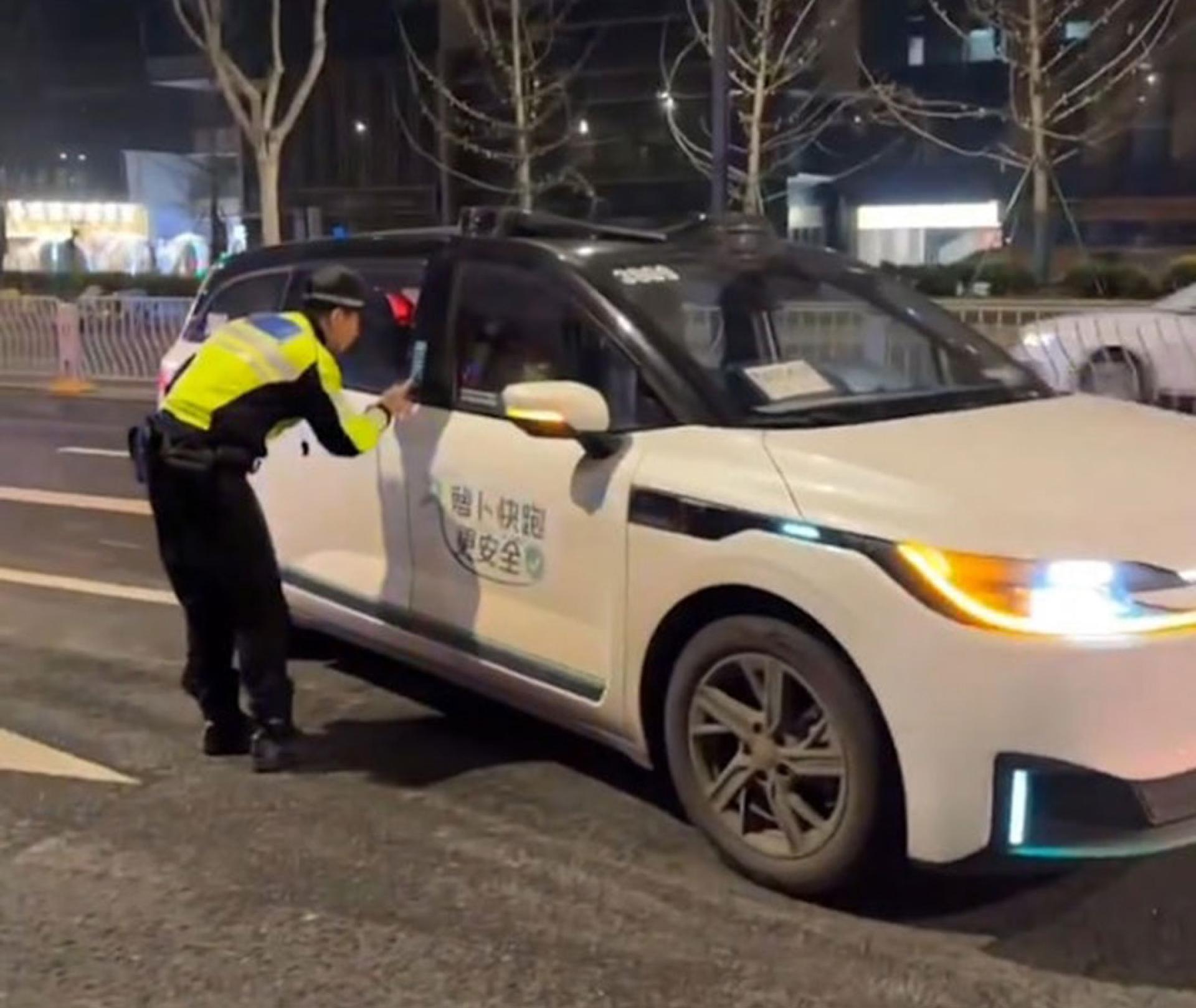 多人乘坐“萝卜快跑”时突然被困，交通警察协助乘客离开。