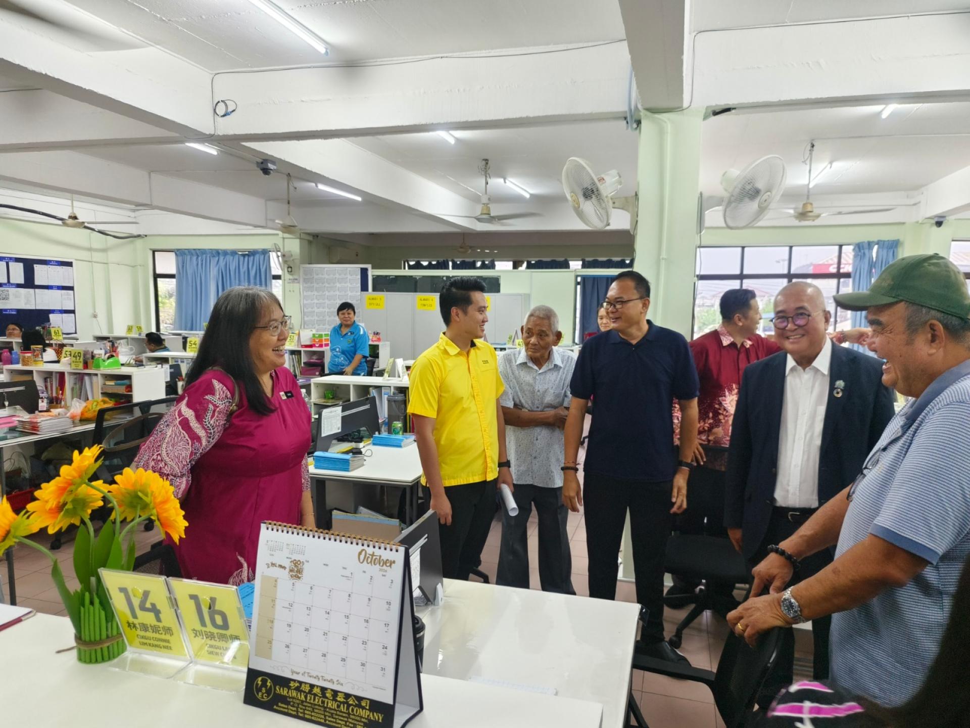 俞小珊（右2）巡视教师办公桌椅环境。