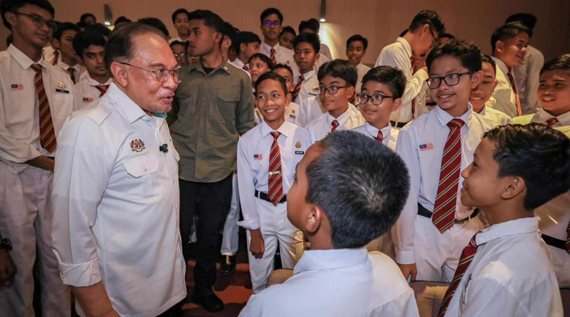 安华在巡视克里福国中并与学生亲切交流。