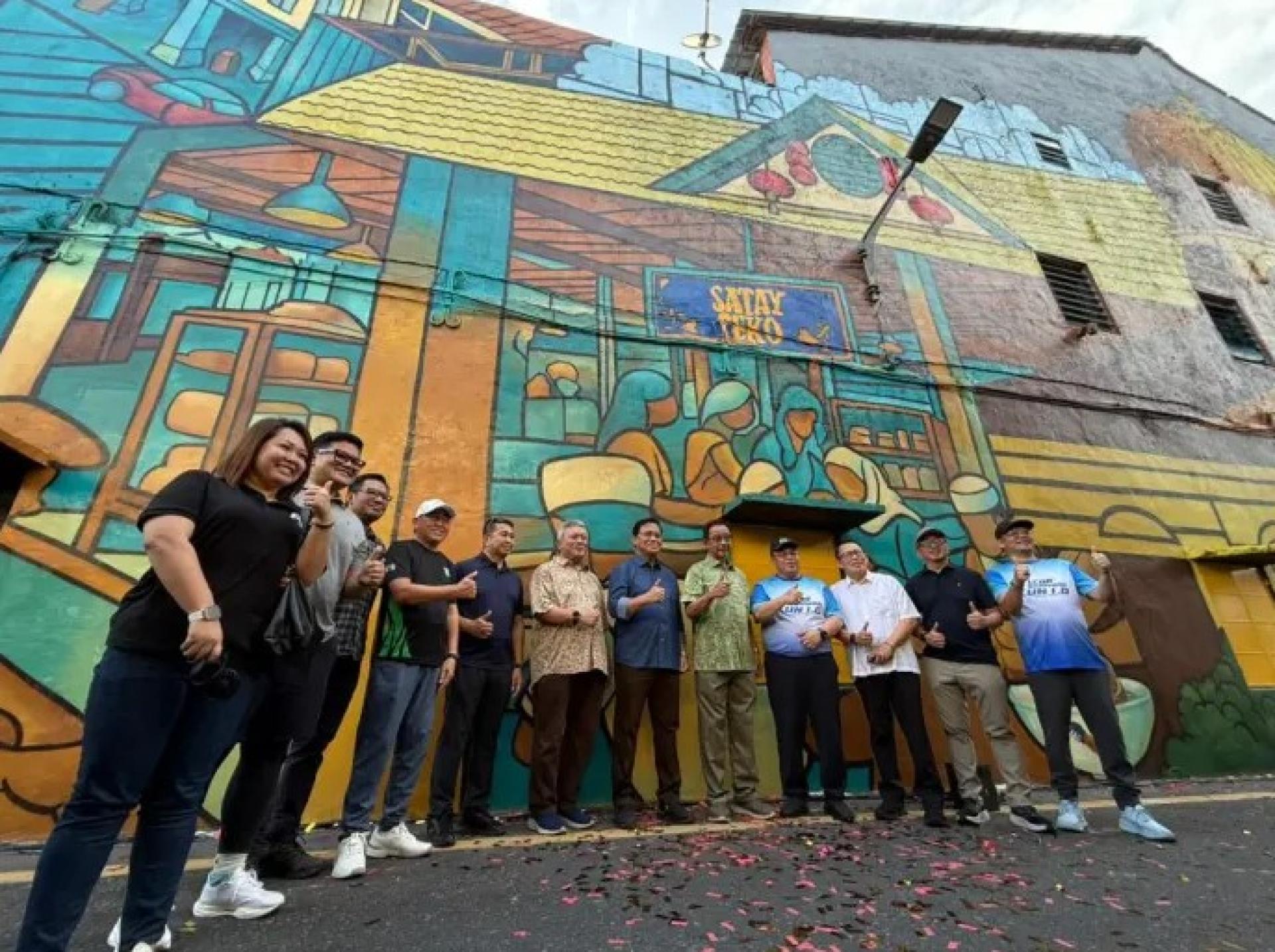 左起第七位：阿都拉赫曼博士、拿督斯里阿都卡林与希尔米，以及其他嘉宾，于2026年4月5日在Brooke船坞附近的Dock Lane新壁画前合影。