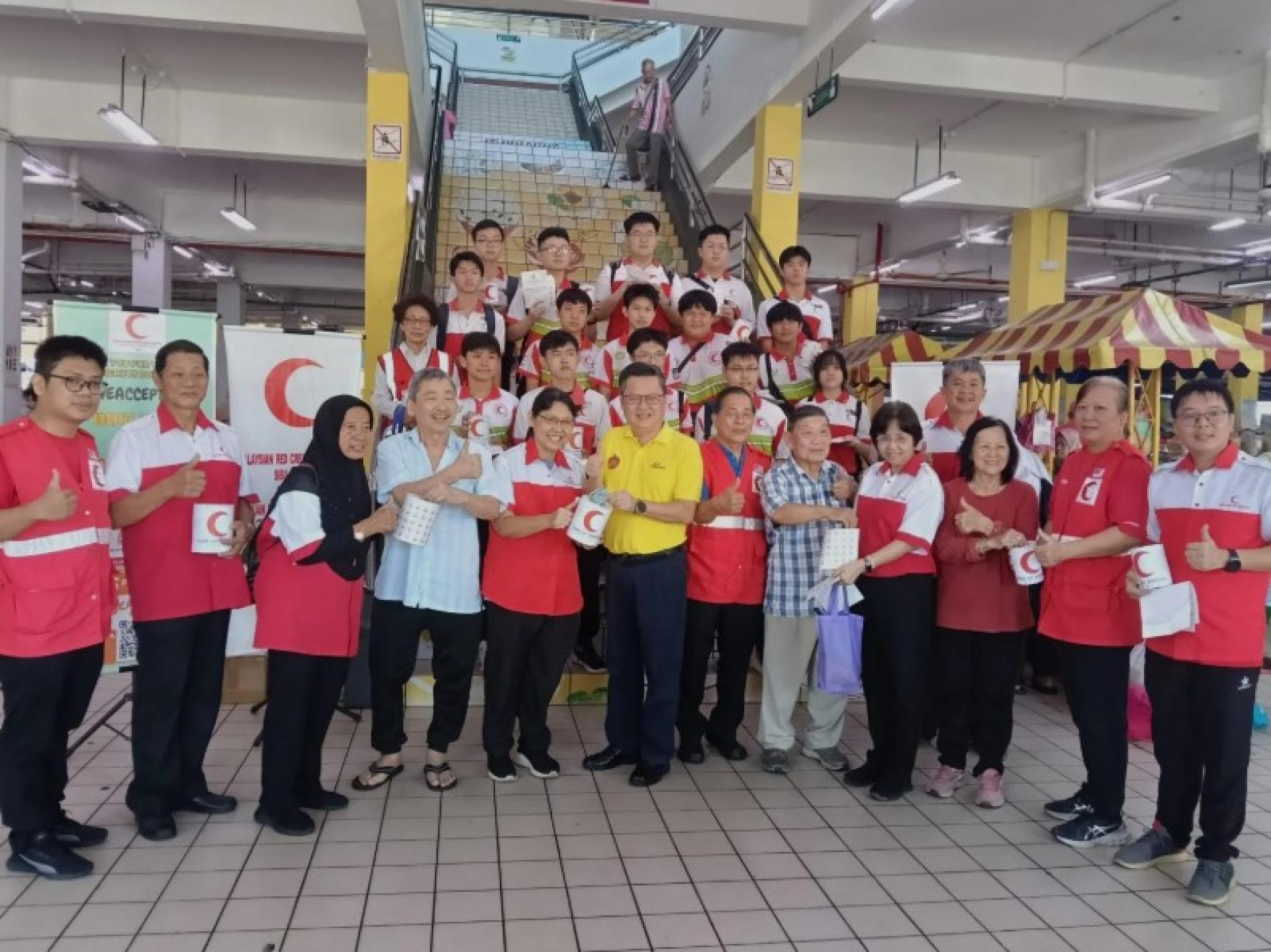 钱进一（左起第六位）在启动仪式上，与Penghulu Chua Hiong Kee（左侧）及其他红新月会成员合影。