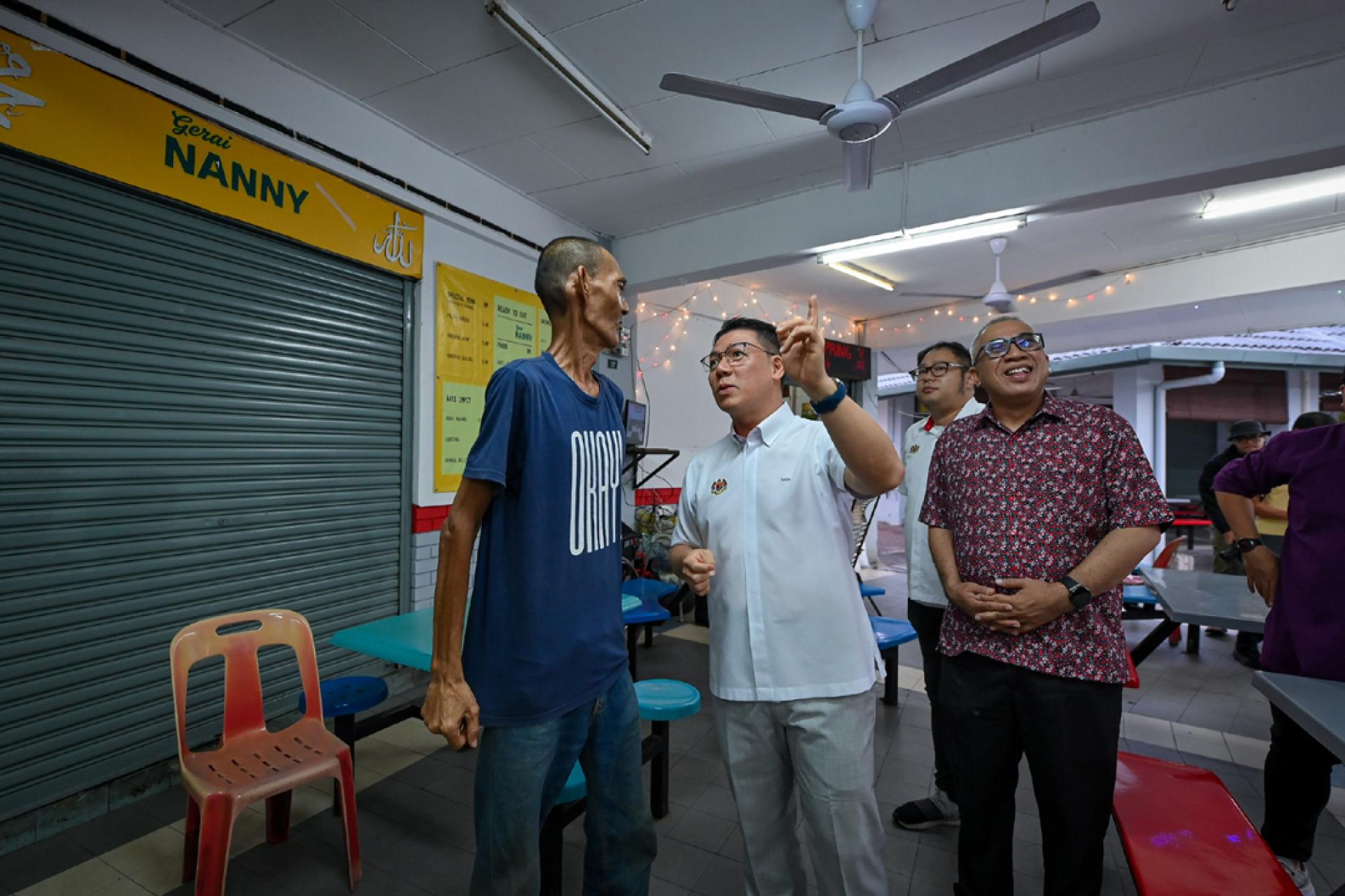 倪可敏（中）与扎马克沙里（右）向民众讲解升级改造的美食广场。