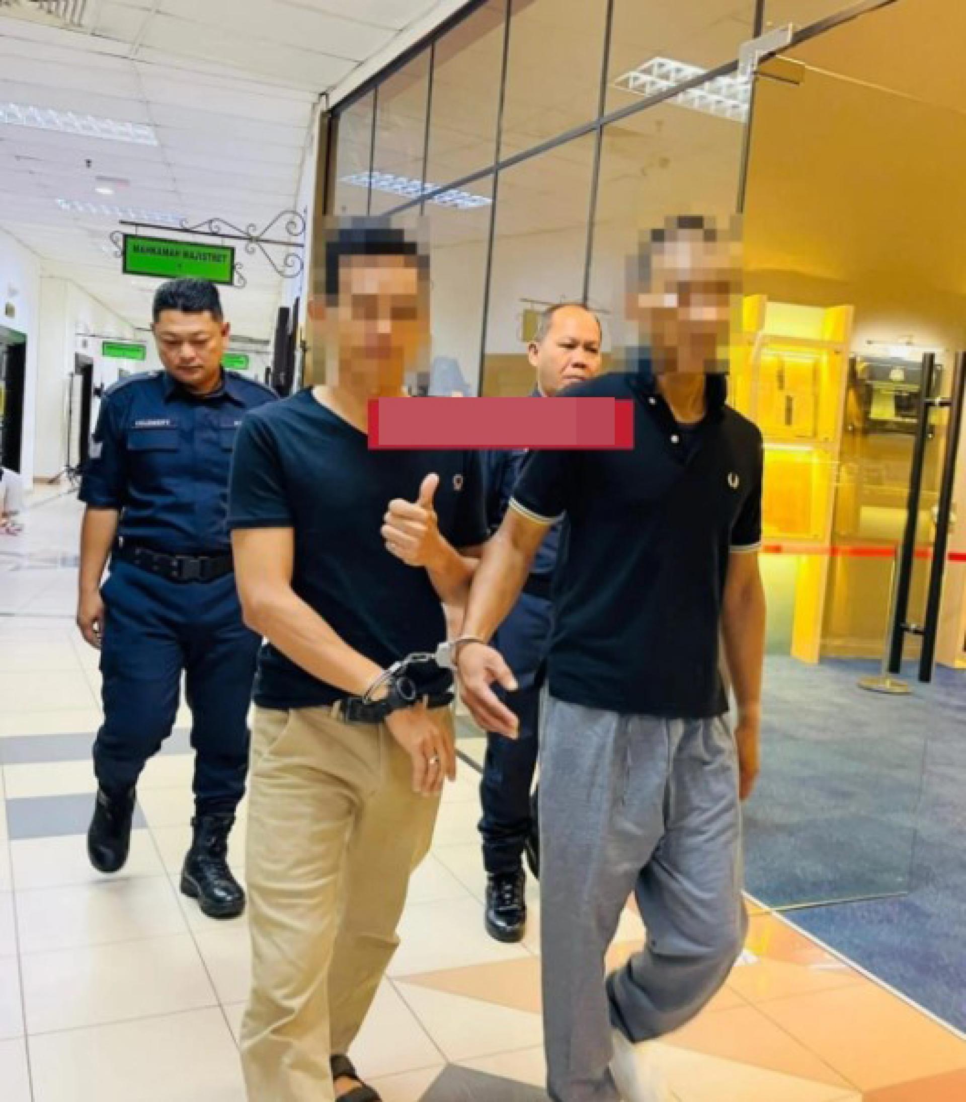 嫌犯（左）从地方法院1号法庭离开时竖起大拇指（示意“最佳”）被警员押送离开，与其他被告一同带走。