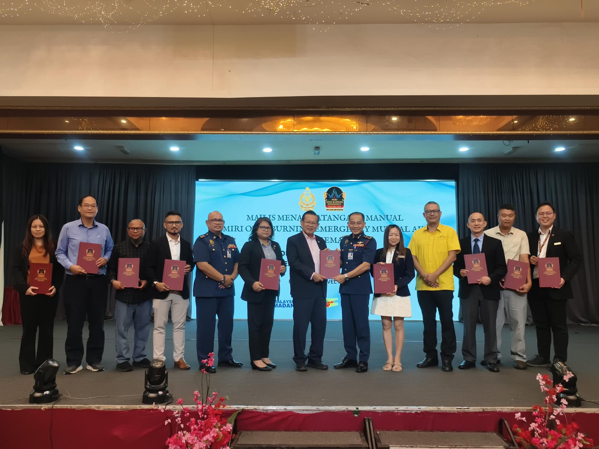 砂交通部长拿督斯里李景胜（左7）移交签署的MOBEMA谅解备忘录给砂拉越消防与拯救局局长占里马斯兰及各企业代表合影。