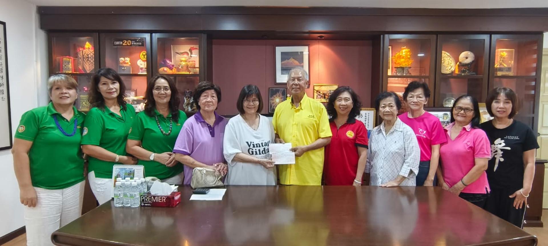 砂旅游部副部长兼美里人工耳蜗协会主席拿督陈超耀（右6）接收由29个团体筹得的1万4000令吉善款，由山顶花园睦龄会妇女组舞蹈班负责人刘爱玉（左）代表移交。