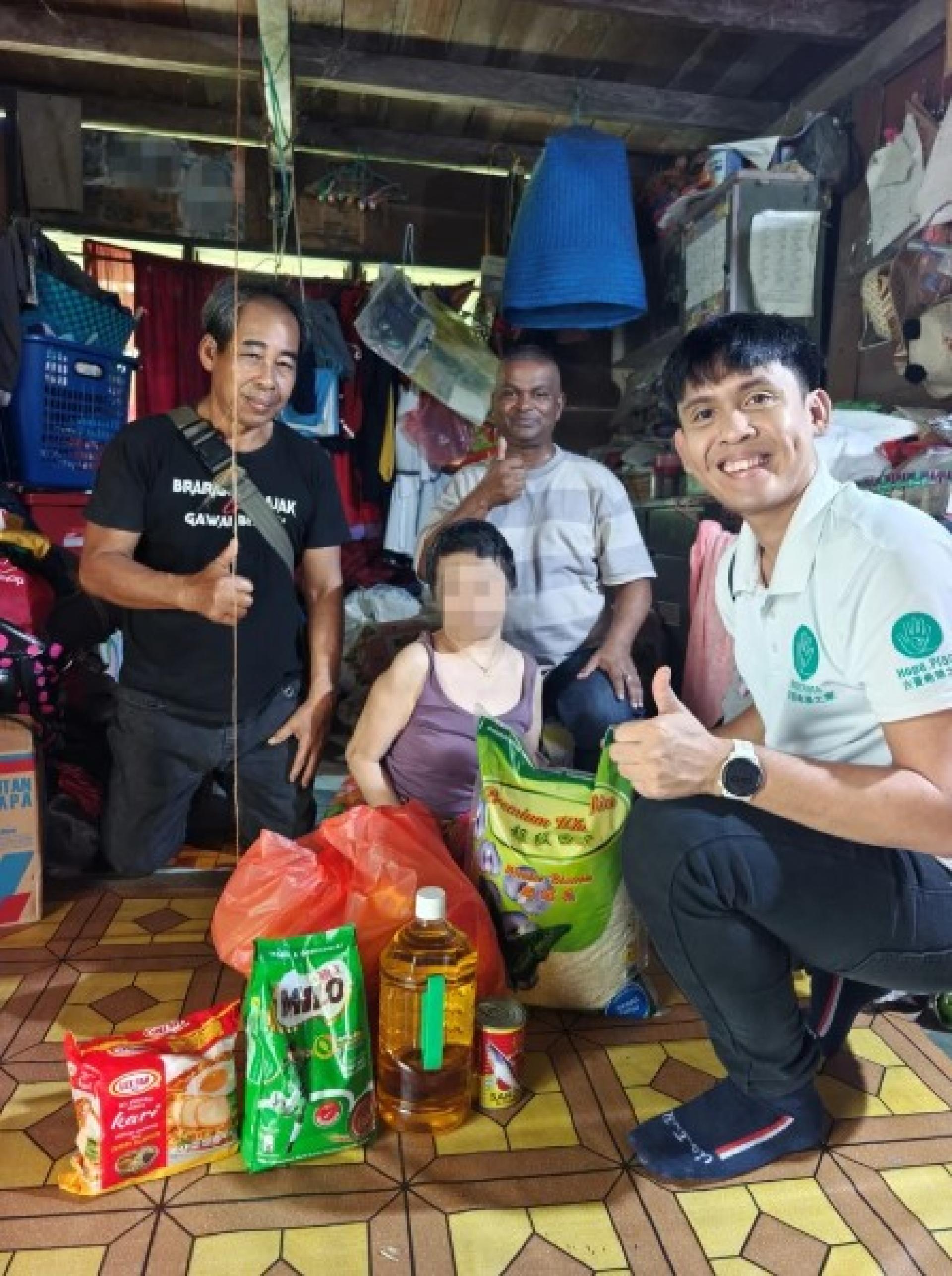 Mamim（左2）接过希望之家的Griffin Deng（右）的援助物资。