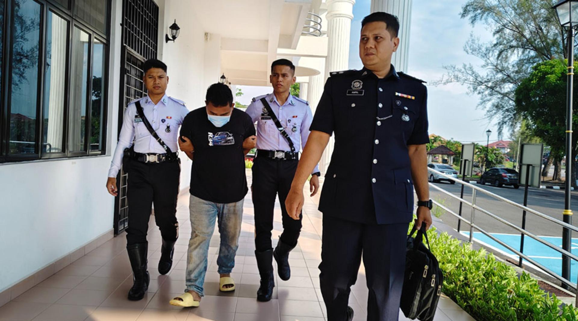 被告幕哈末凯鲁尼（左2），在警员押送下前往推事庭面控。