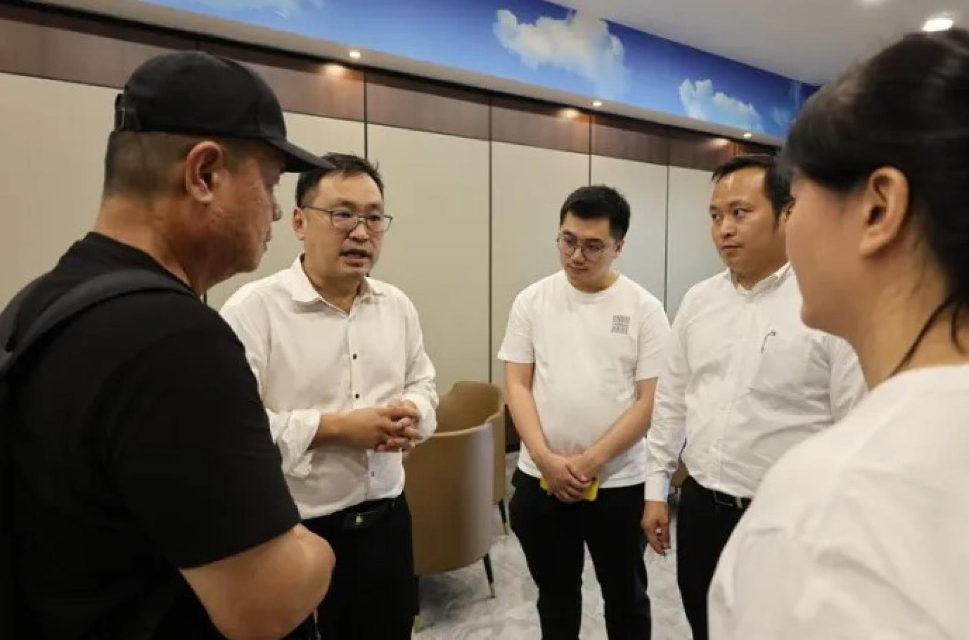 张健仁（左2）于2026年4月7日在五哩半展丧事殡仪馆与林嘉祥家属交谈。